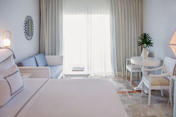 a room with a bed and a table and chairs