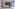 Modern living room, light sofa, dark wood media, marble floor, ocean view.