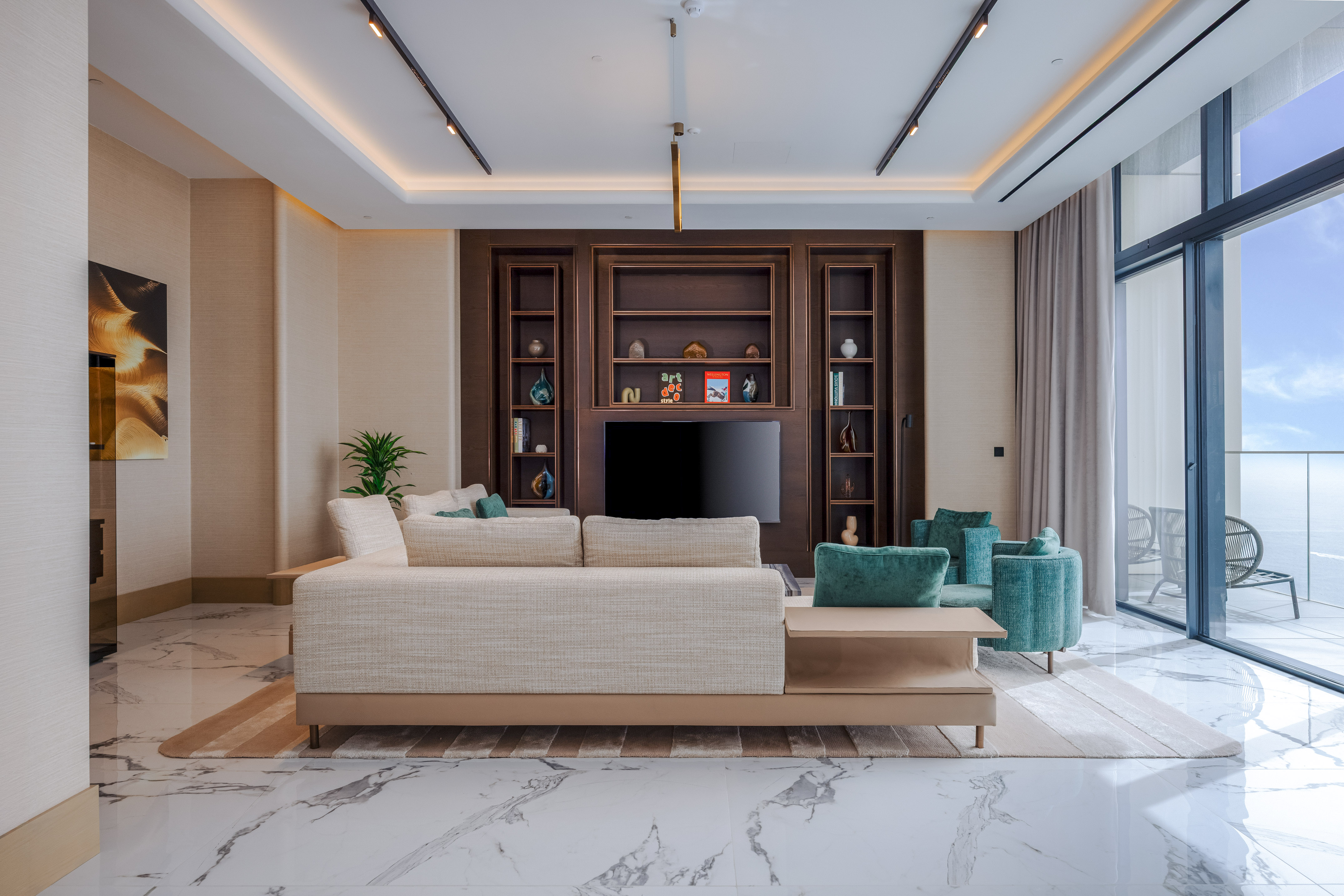Modern living room, light sofa, dark wood media, marble floor, ocean view.