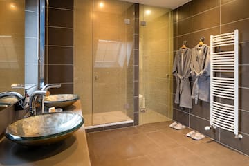 a bathroom with a glass shower door and two sinks