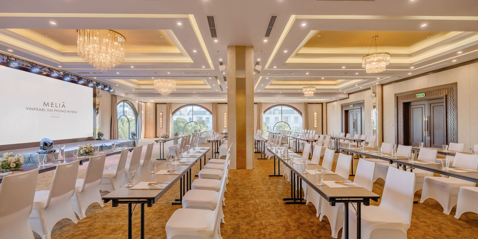 sảnh lớn có đèn chùm lớn và bàn được bày biện hoa