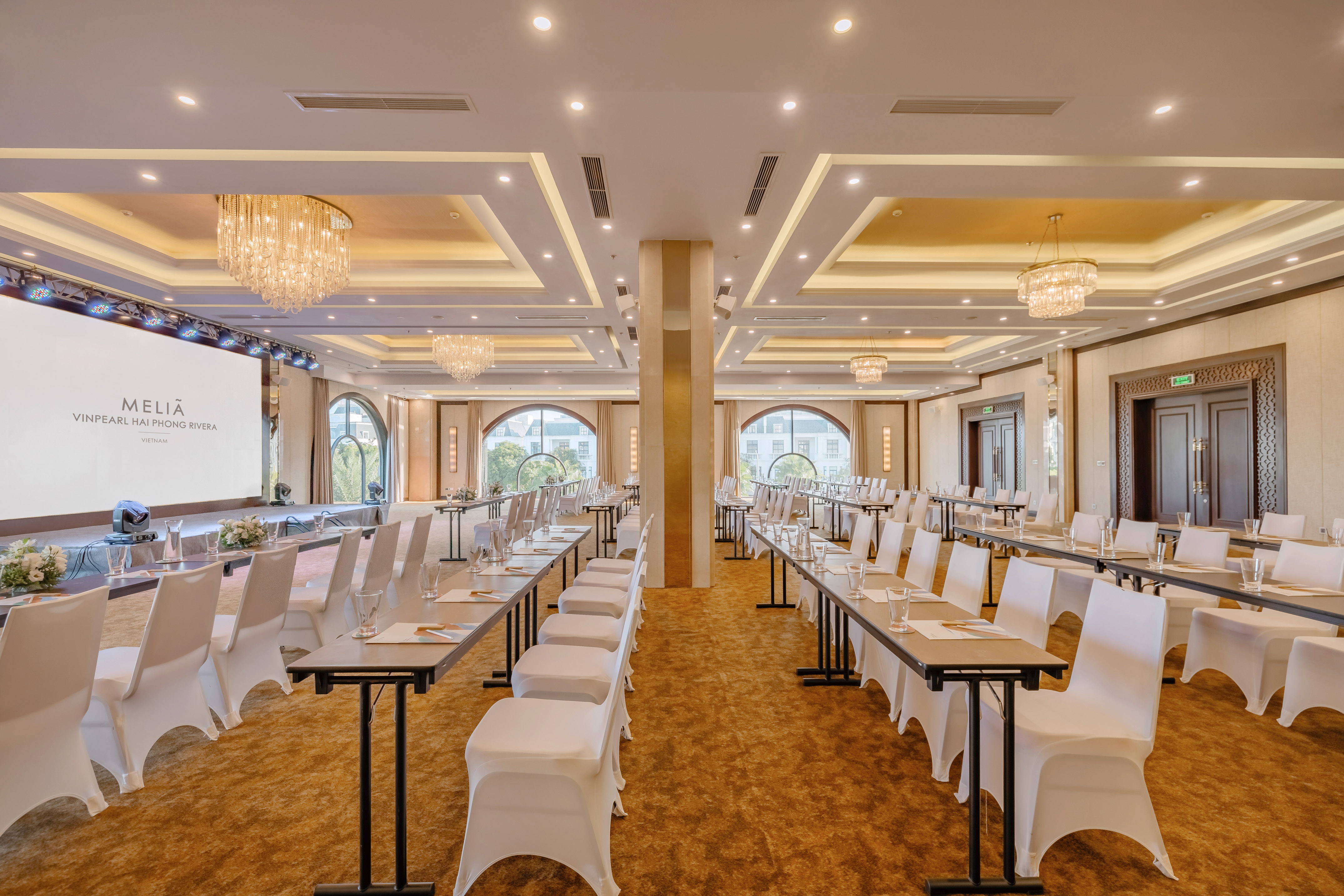 un grand hall d'entrée avec un grand lustre et une table avec des fleurs