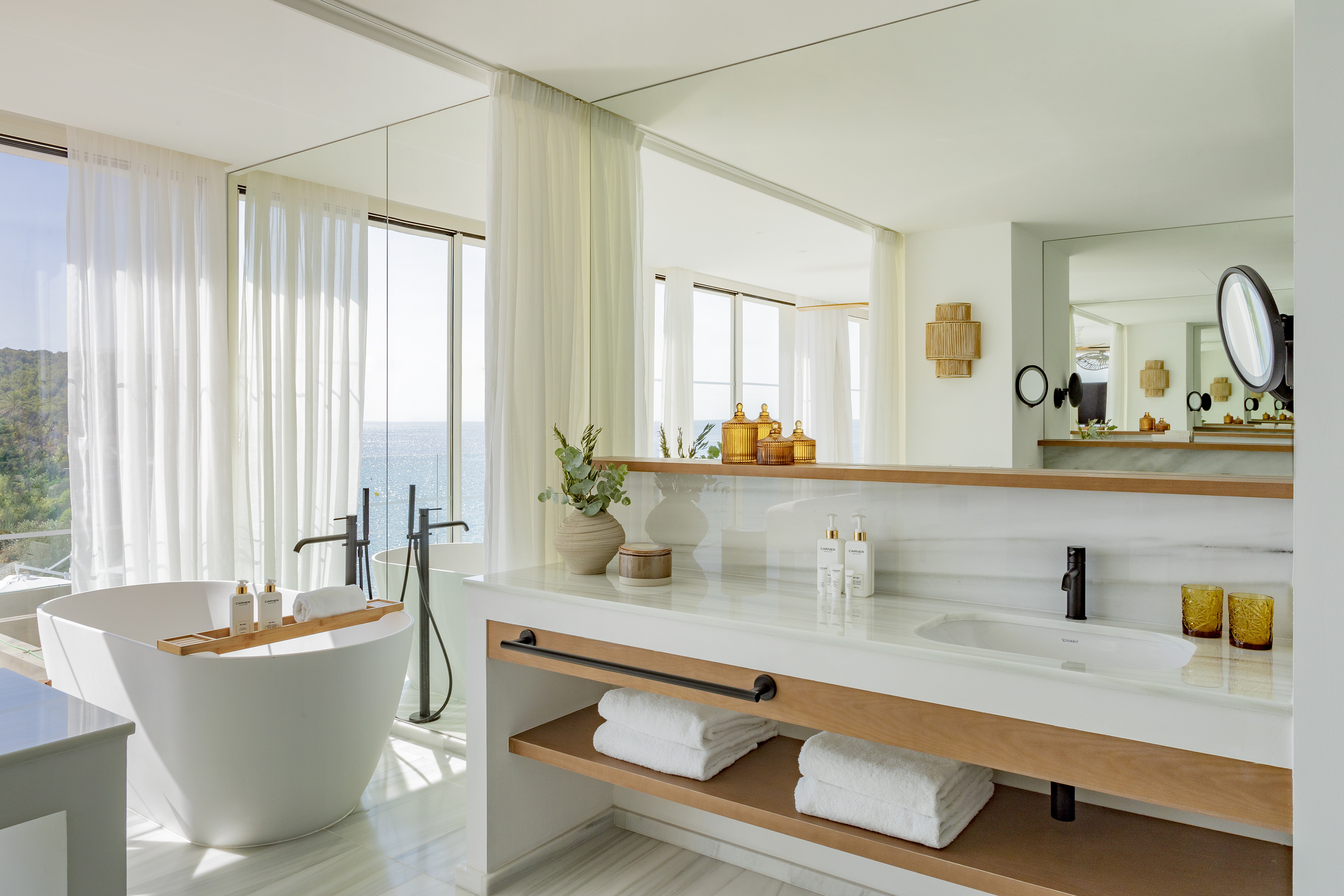 Luxury bathroom with ocean view, freestanding tub, and modern vanity.