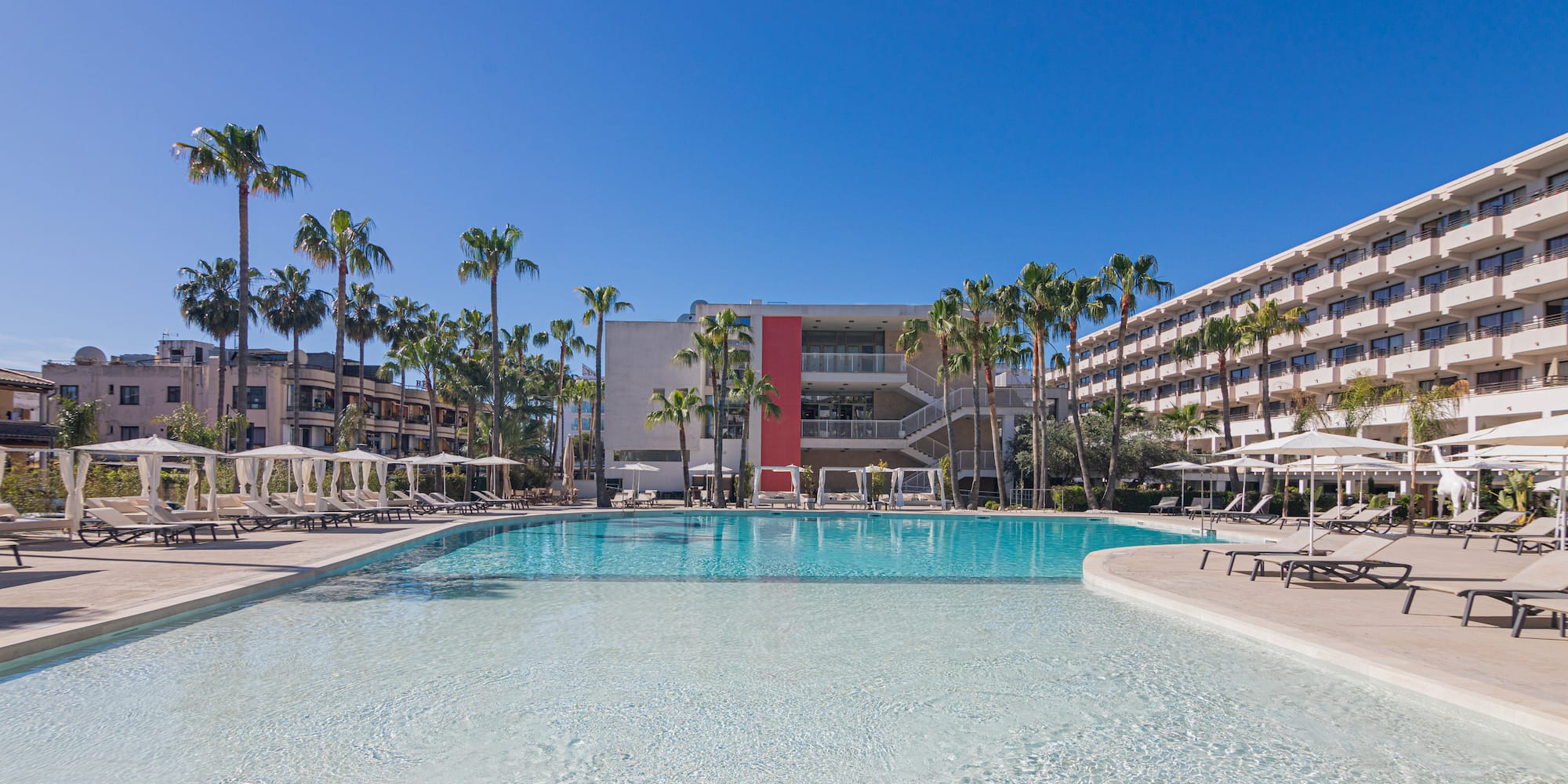 a pool with lounge chairs and palm trees