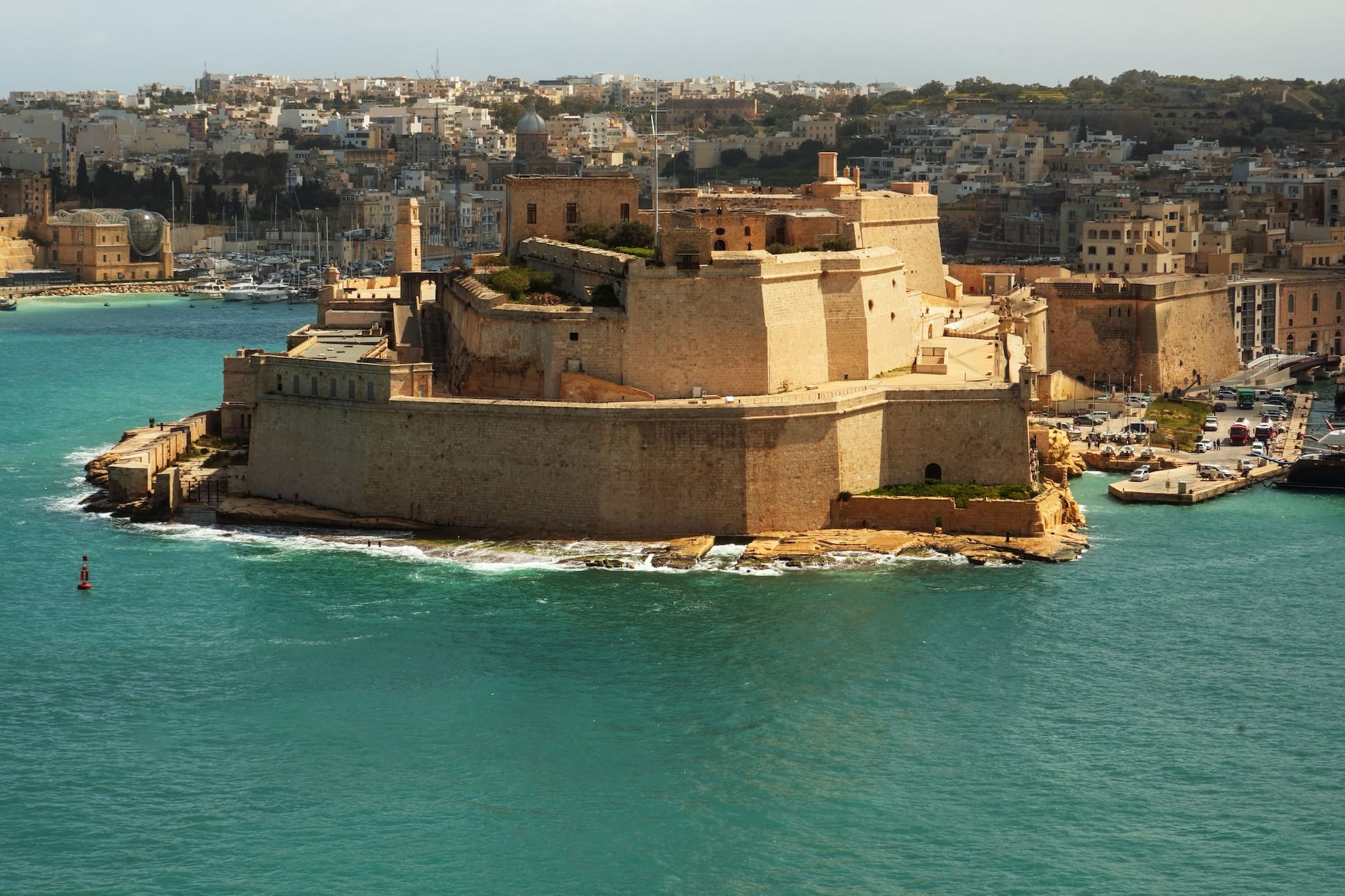 Fort St Angelo, Malta, with cannons overlooking turquoise Grand Harbour.