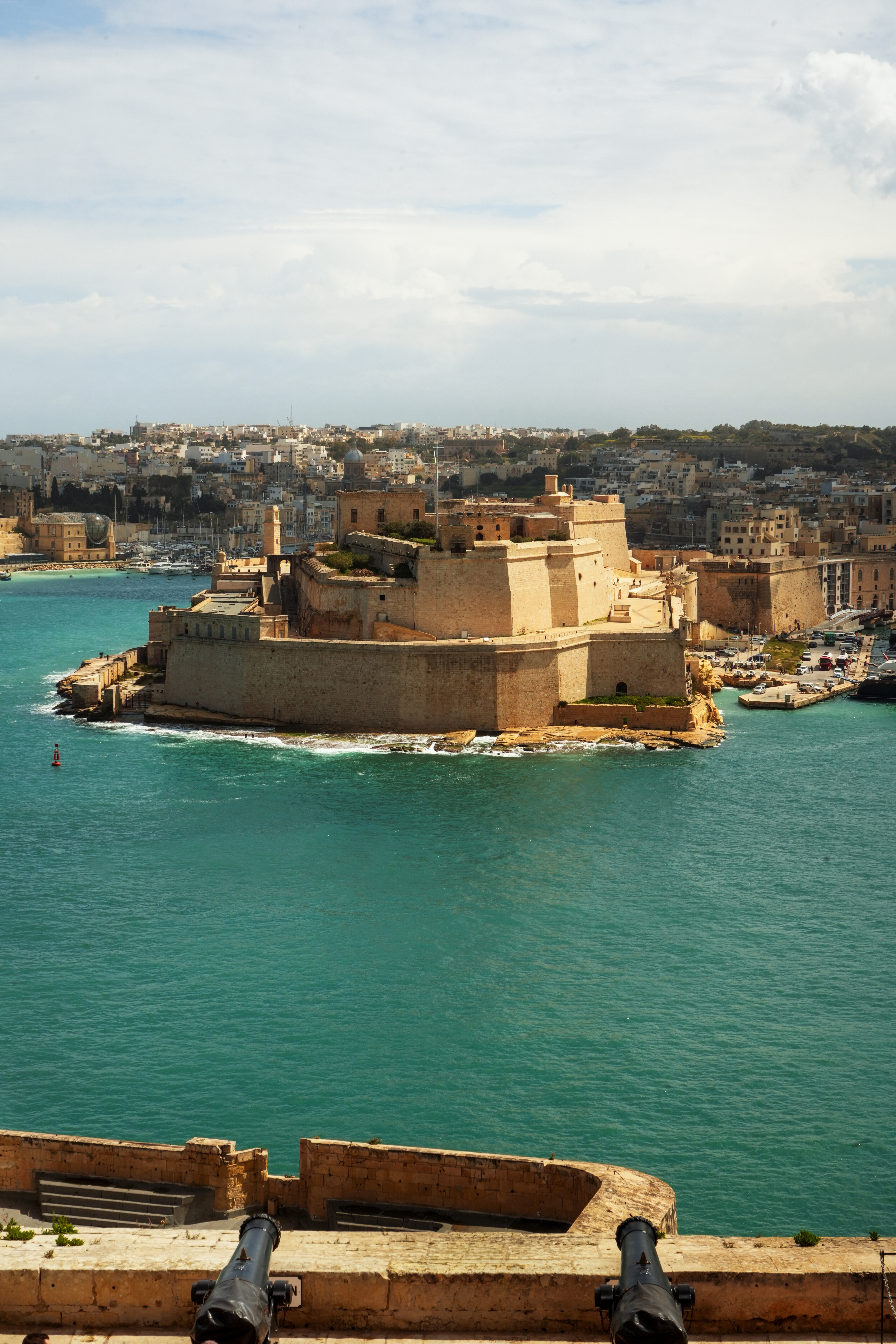 Fort St Angelo, Malta, with cannons overlooking turquoise Grand Harbour.