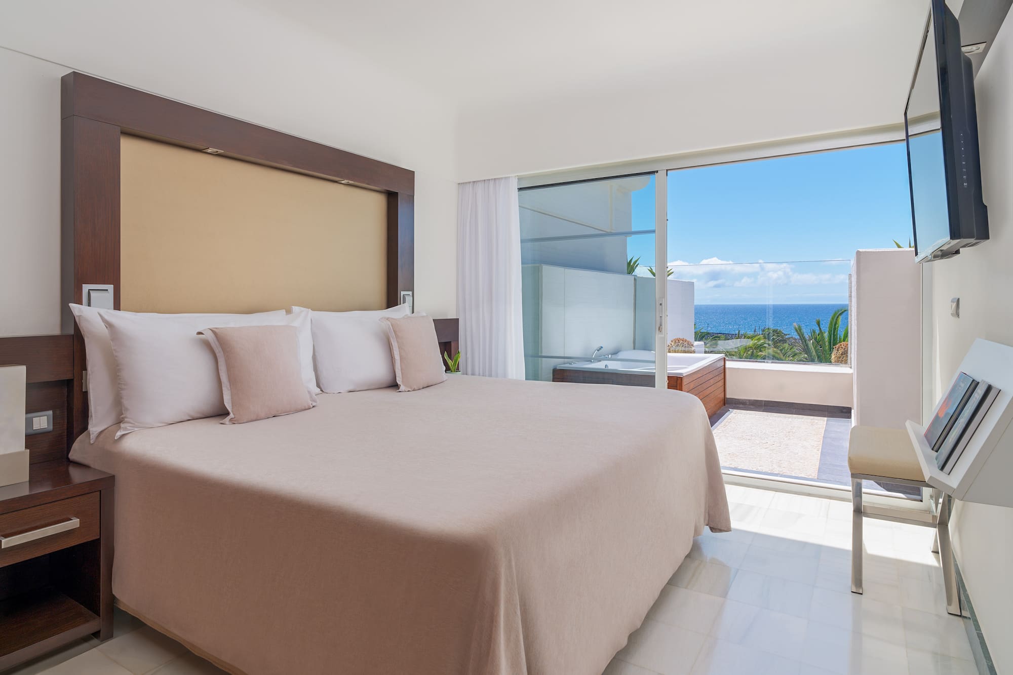a bed with pillows in a room with a glass door