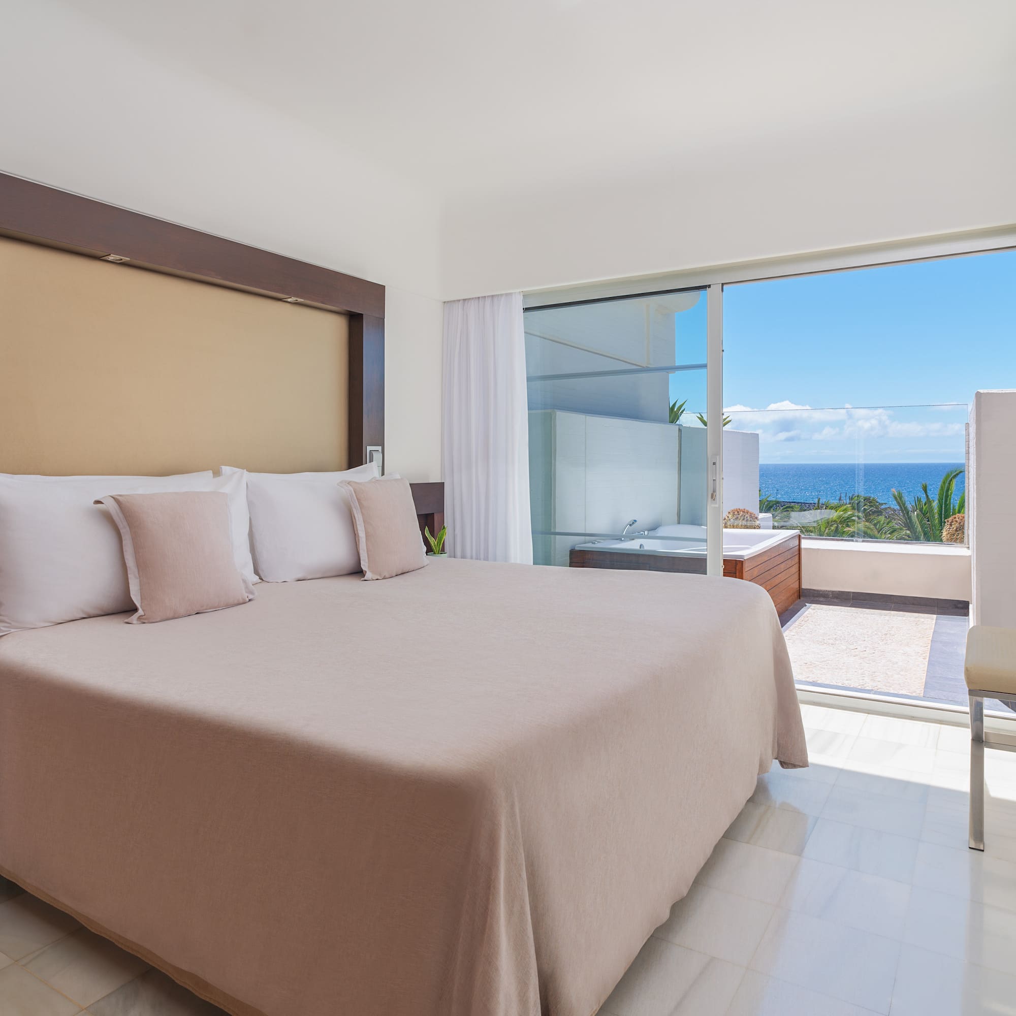 a bed with pillows in a room with a glass door