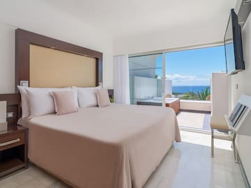 a bed with pillows in a room with a glass door