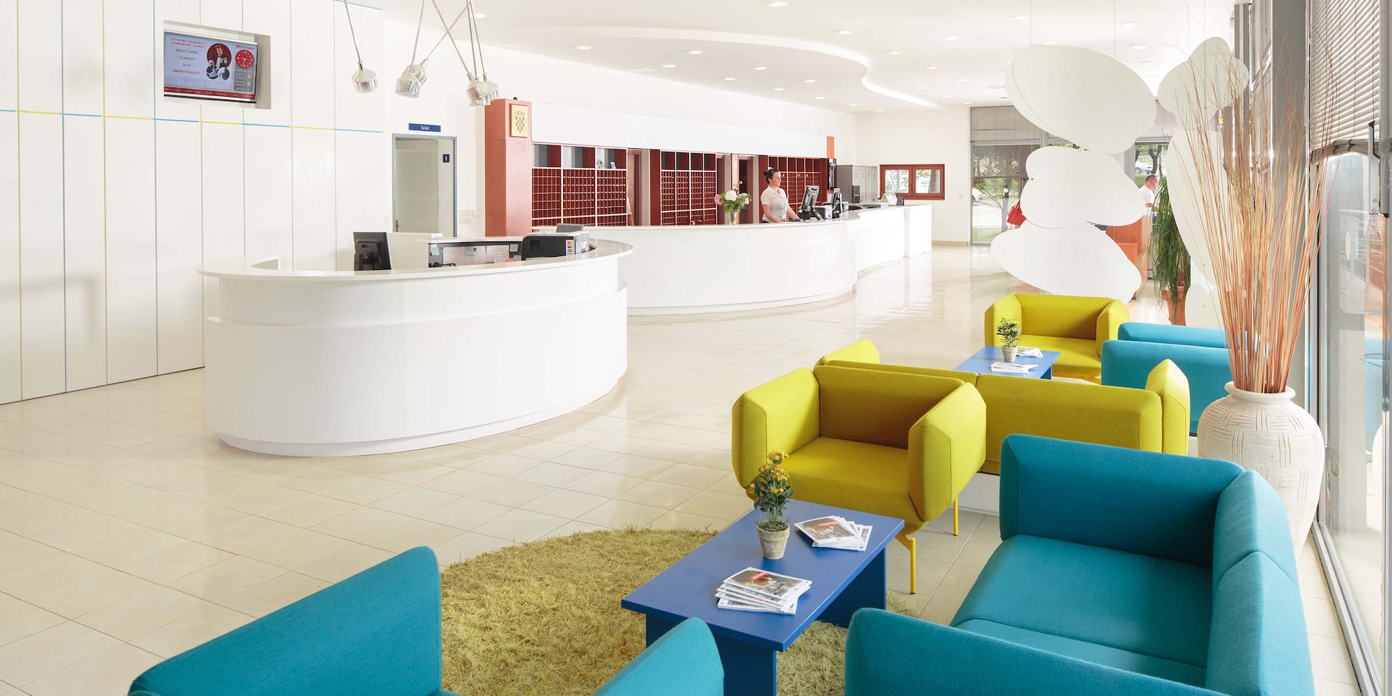 a reception area with blue and yellow chairs