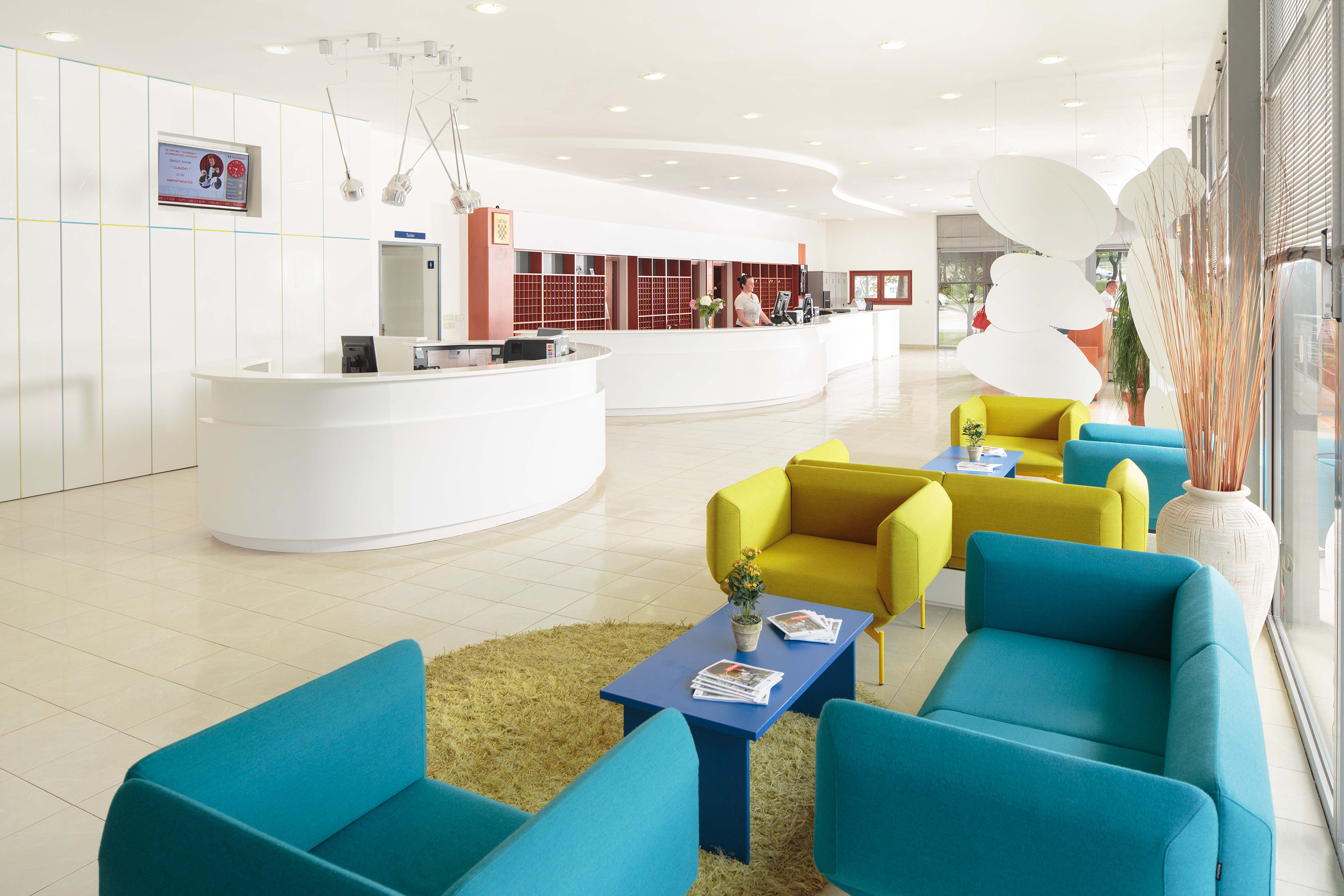 a reception area with blue and yellow chairs