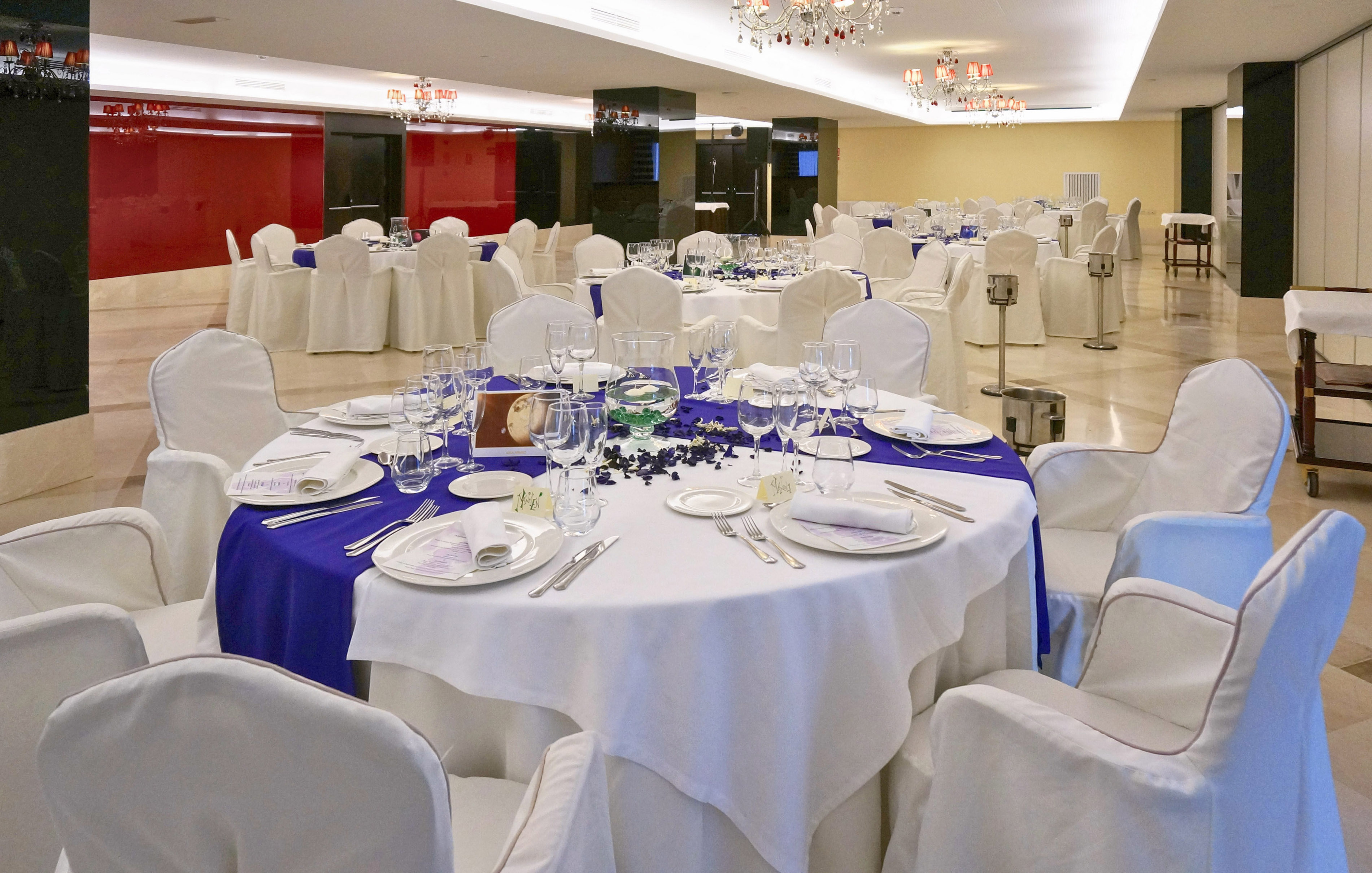 Elegant banquet hall with blue and white tables and chairs for events.
