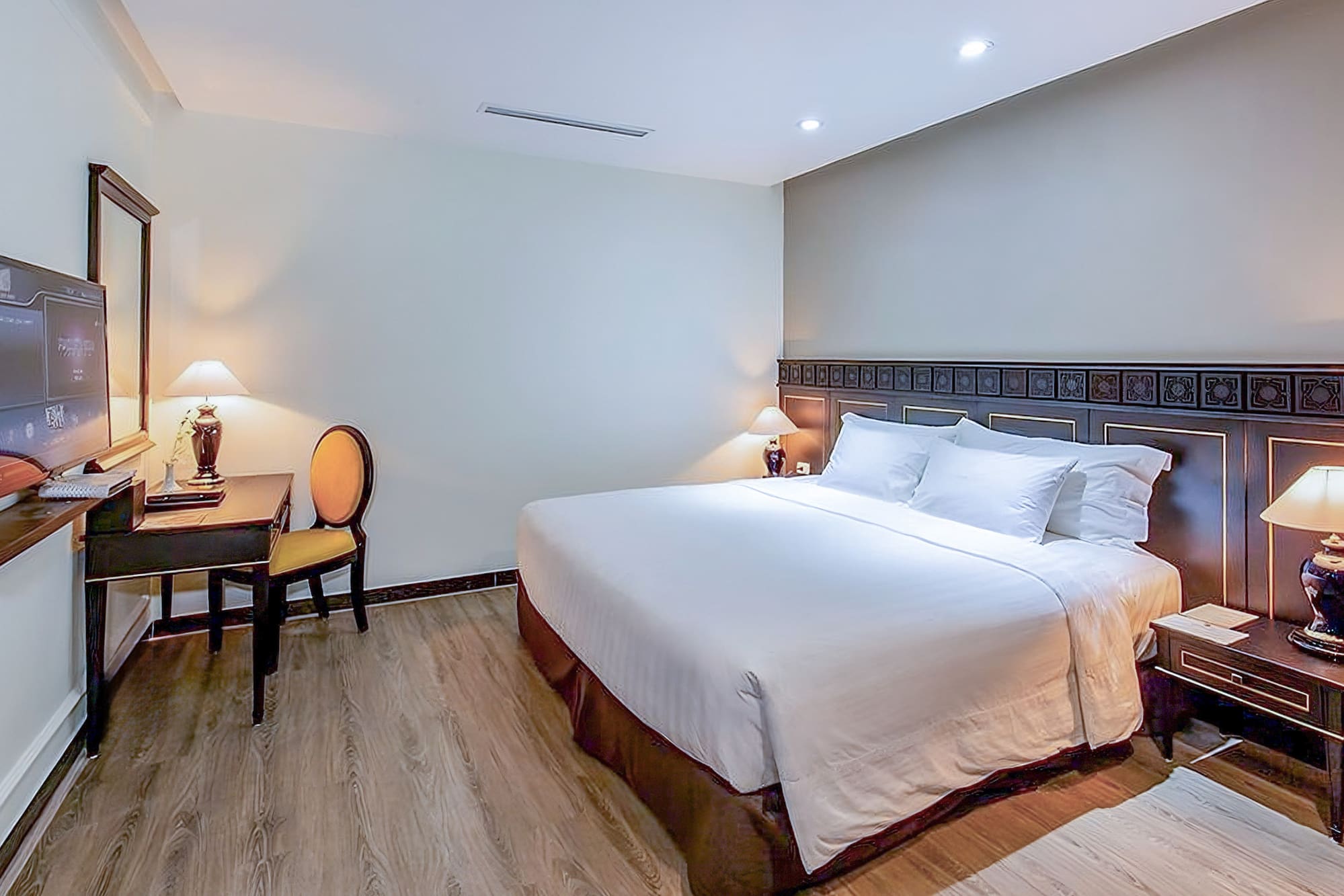 a bed with white sheets and a table and chairs in a room
