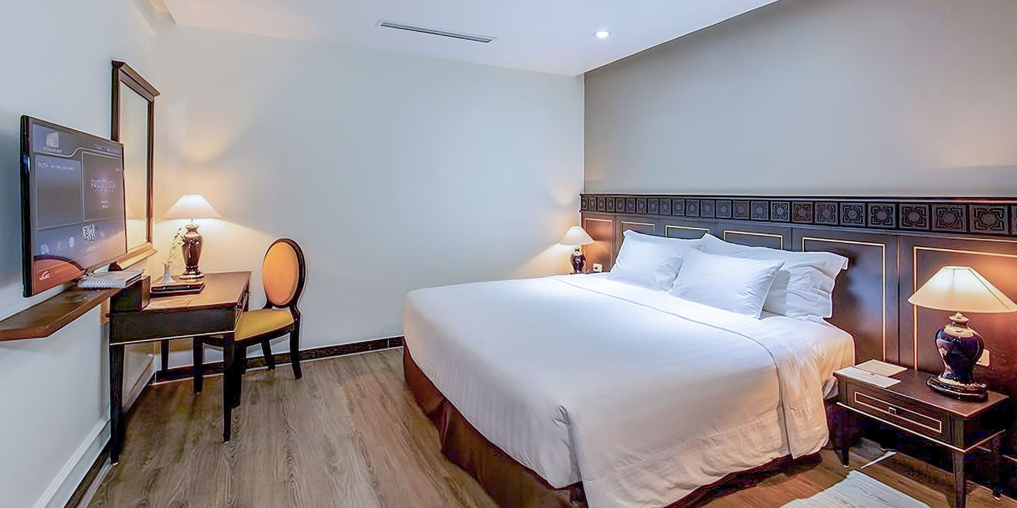 a bed with white sheets and a table and chairs in a room