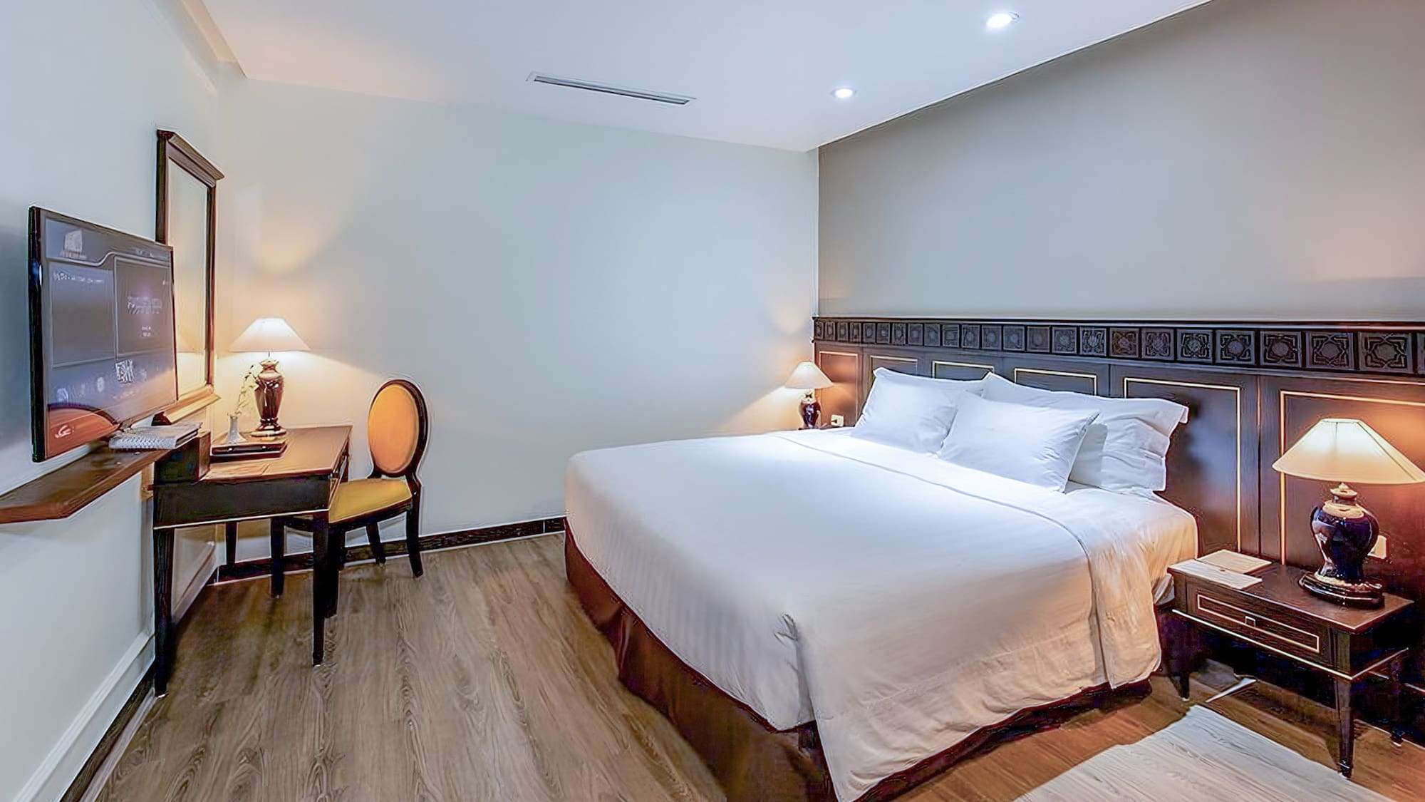 a bed with white sheets and a table and chairs in a room