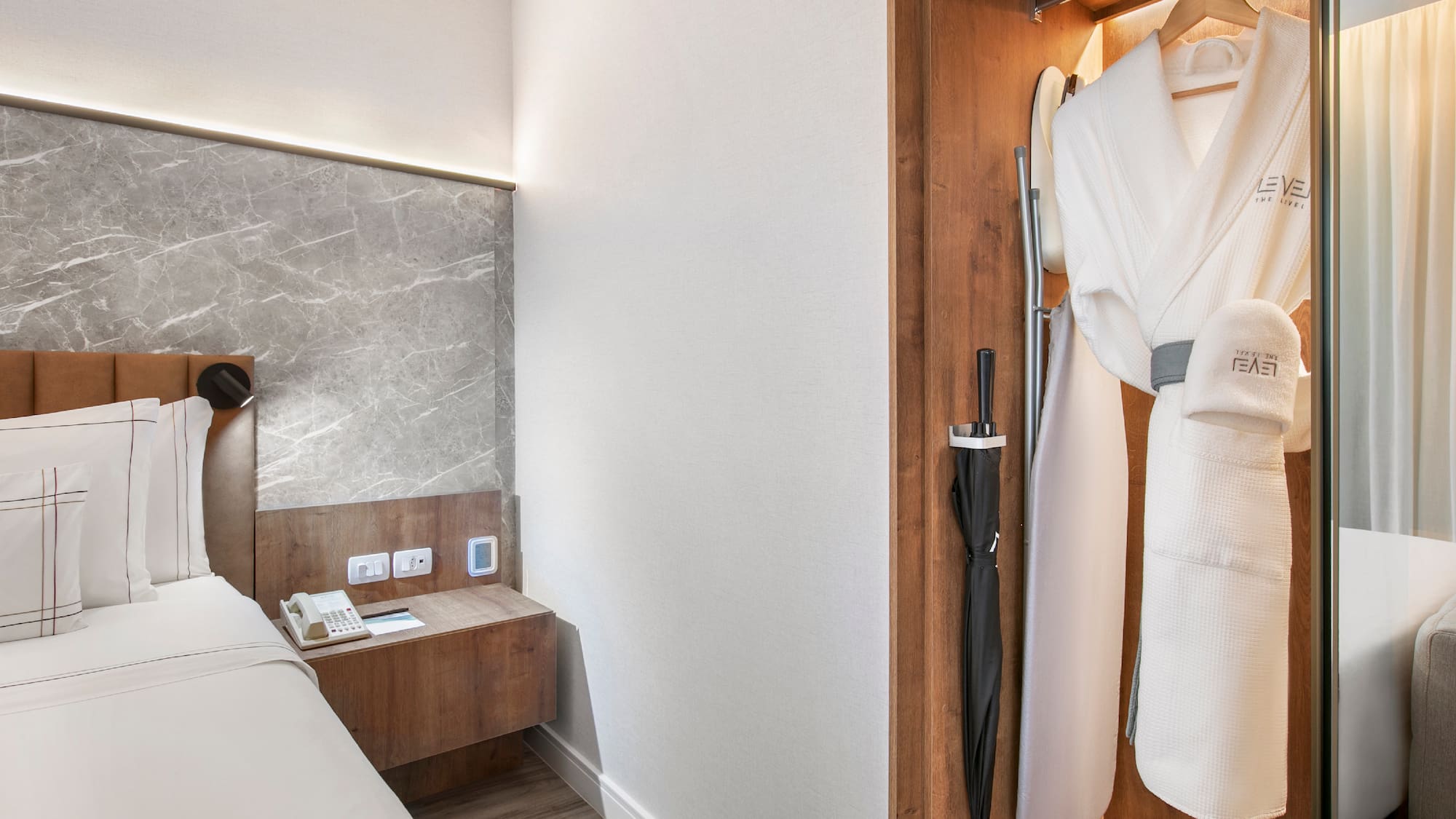 a room with a bed and a robe in a closet