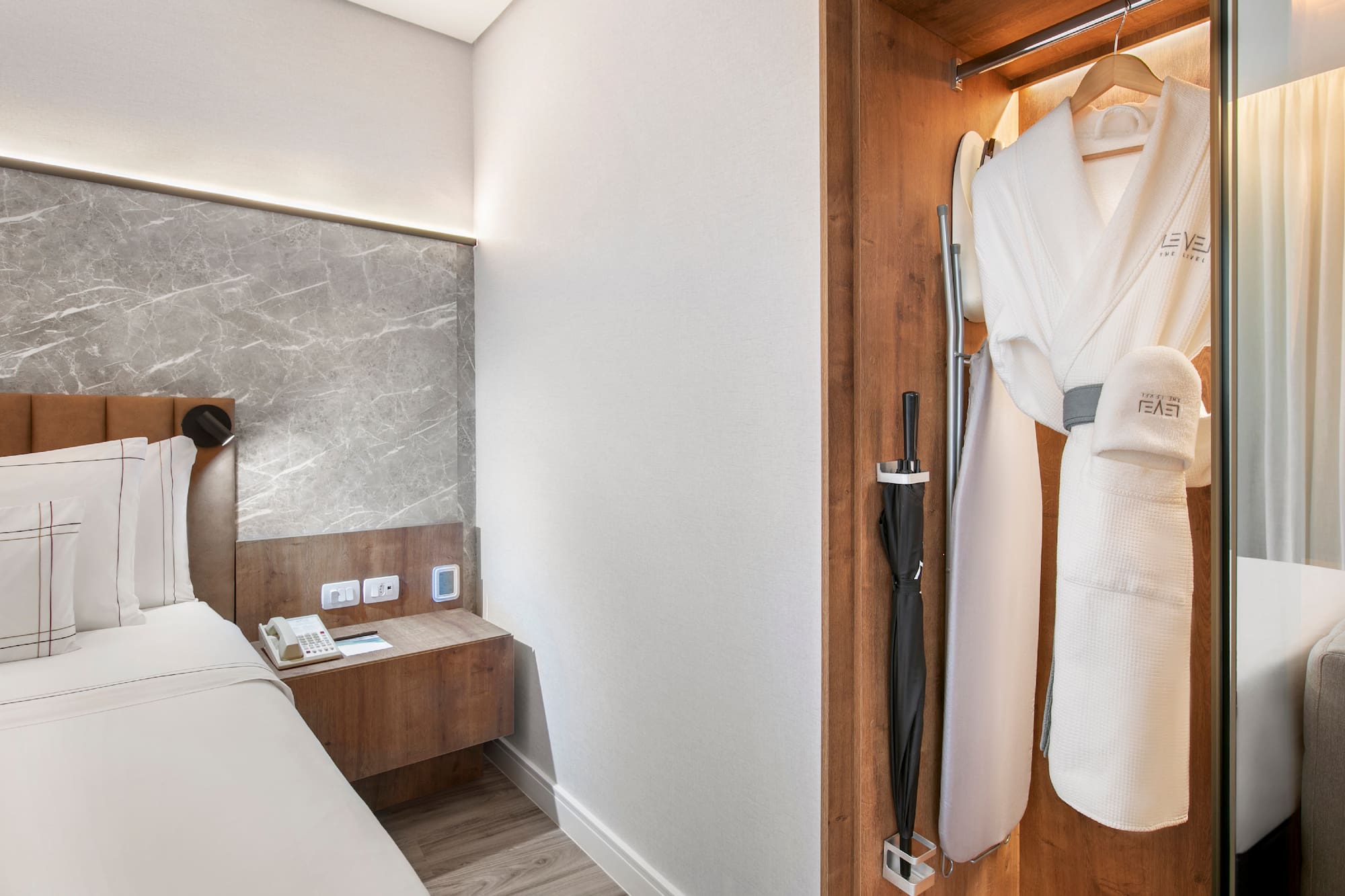 a room with a bed and a robe in a closet