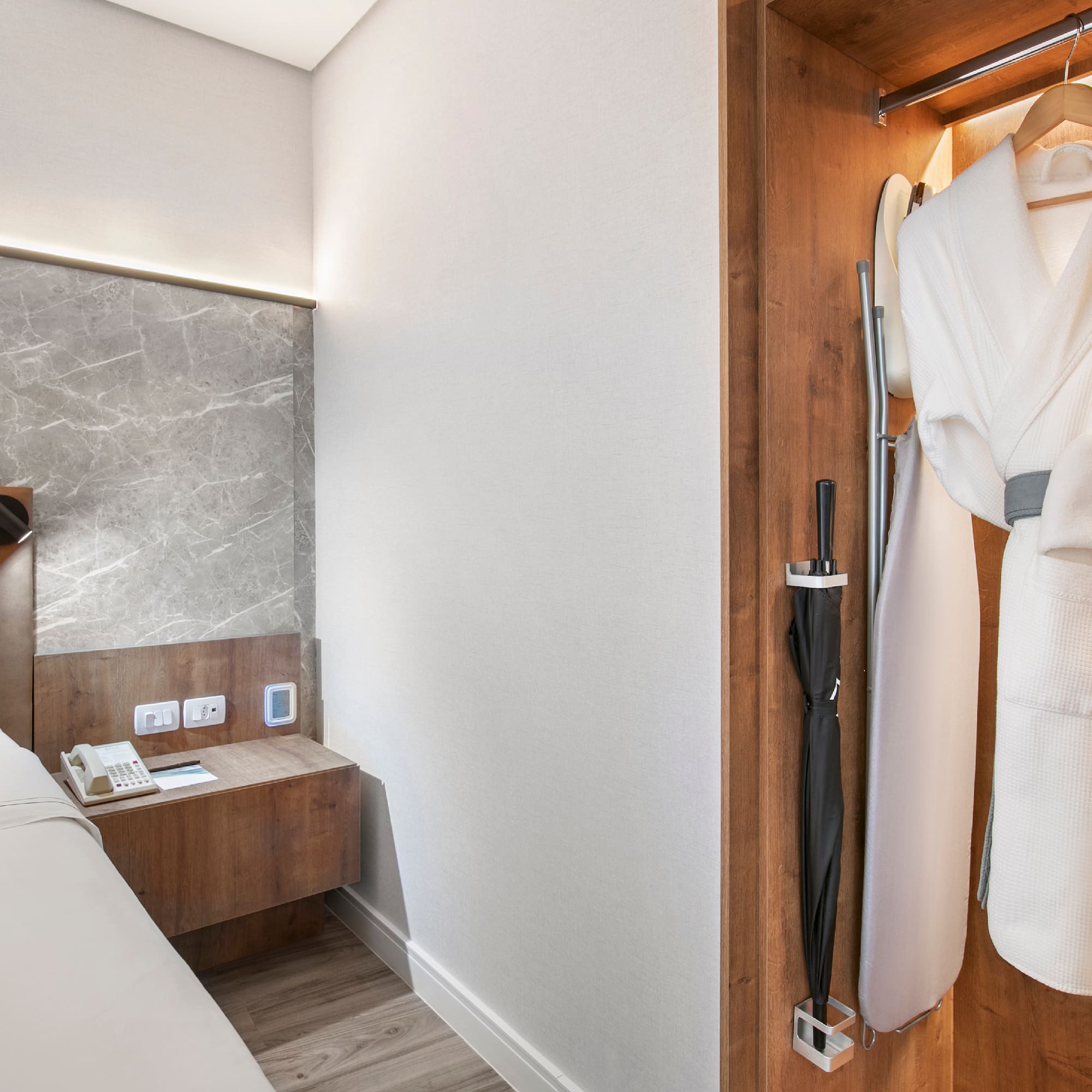 a room with a bed and a robe in a closet