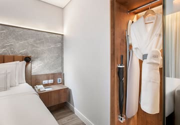 a room with a bed and a robe in a closet