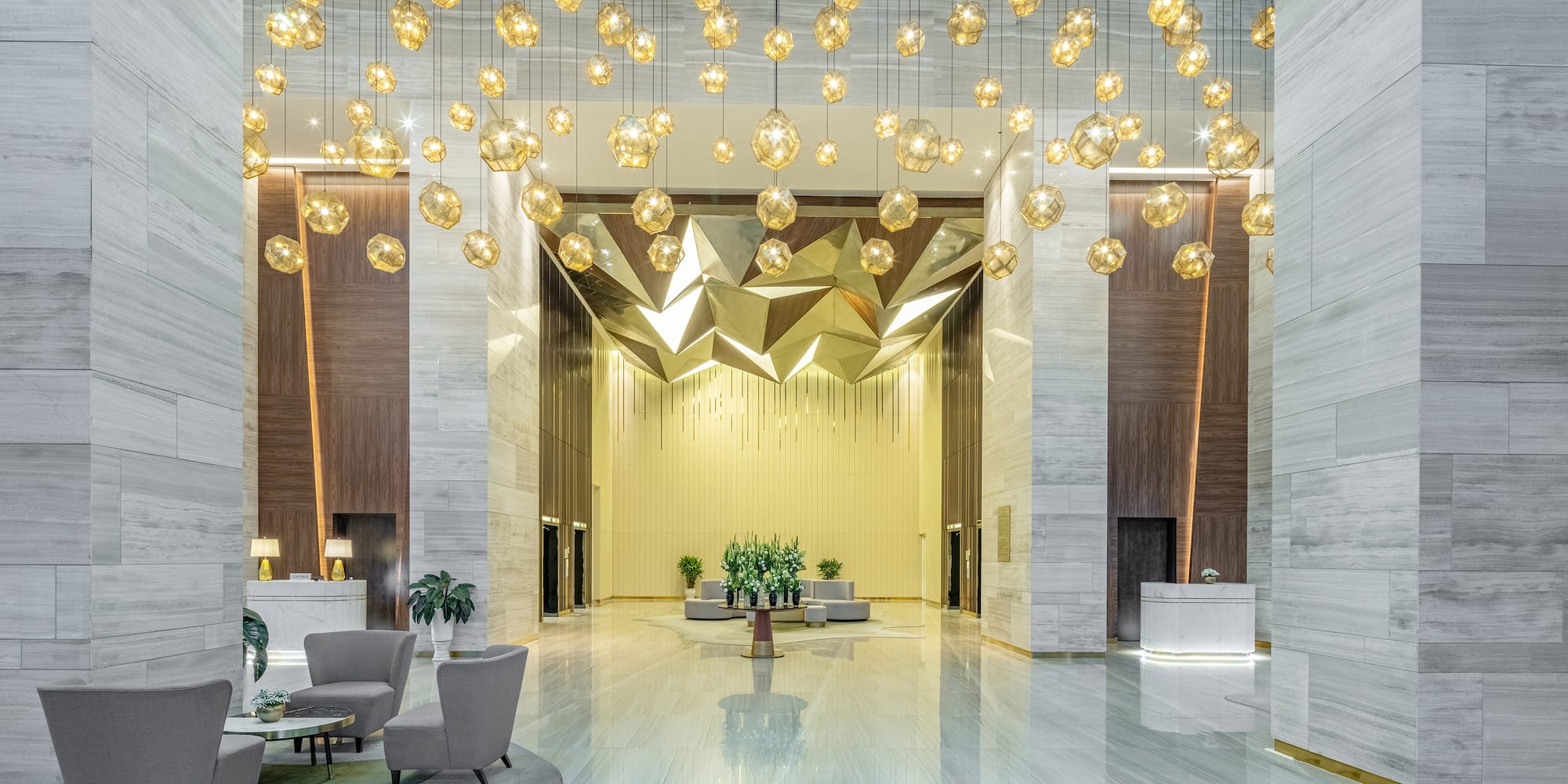a lobby with chandeliers and chairs