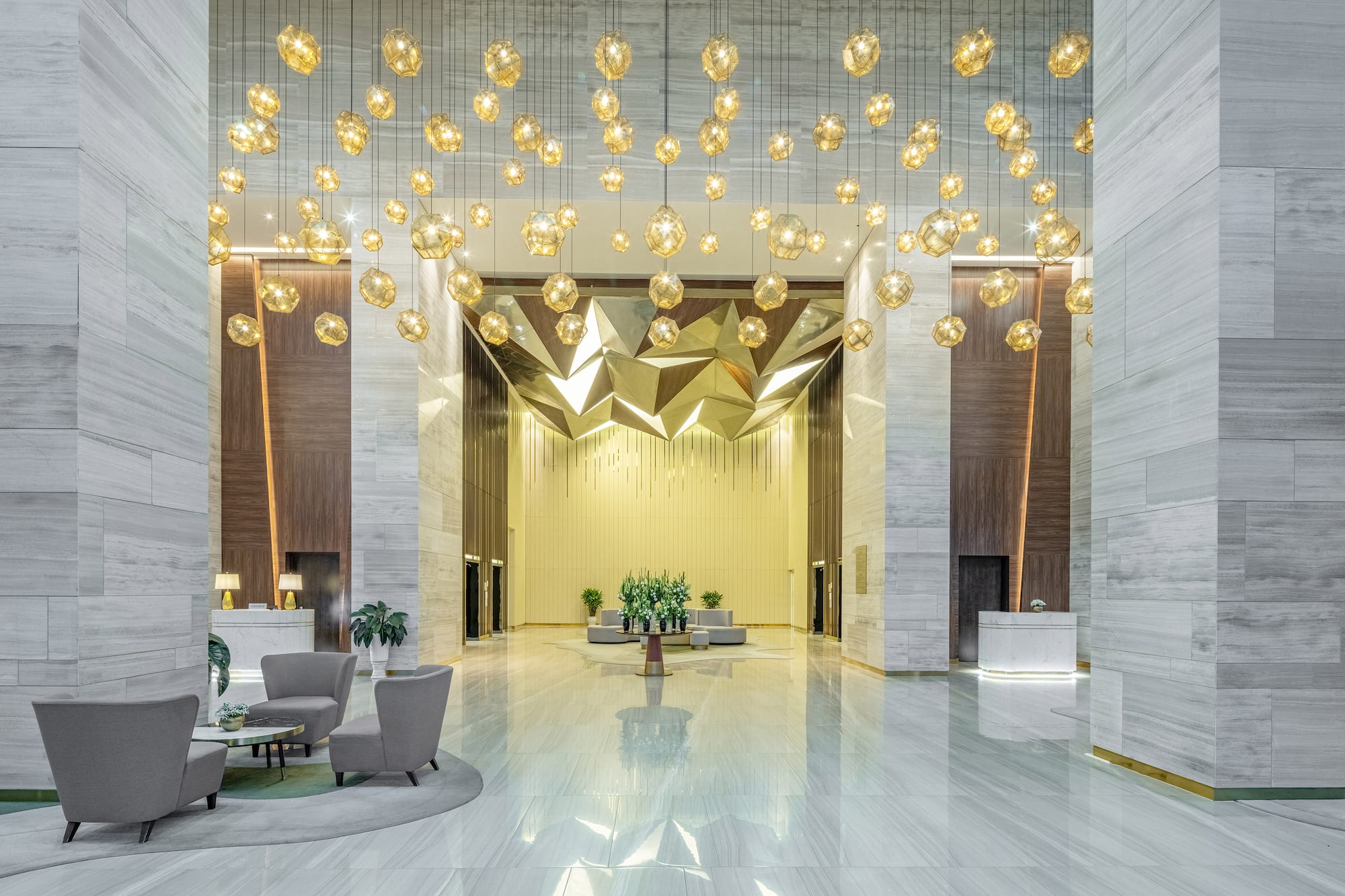 a lobby with chandeliers and chairs