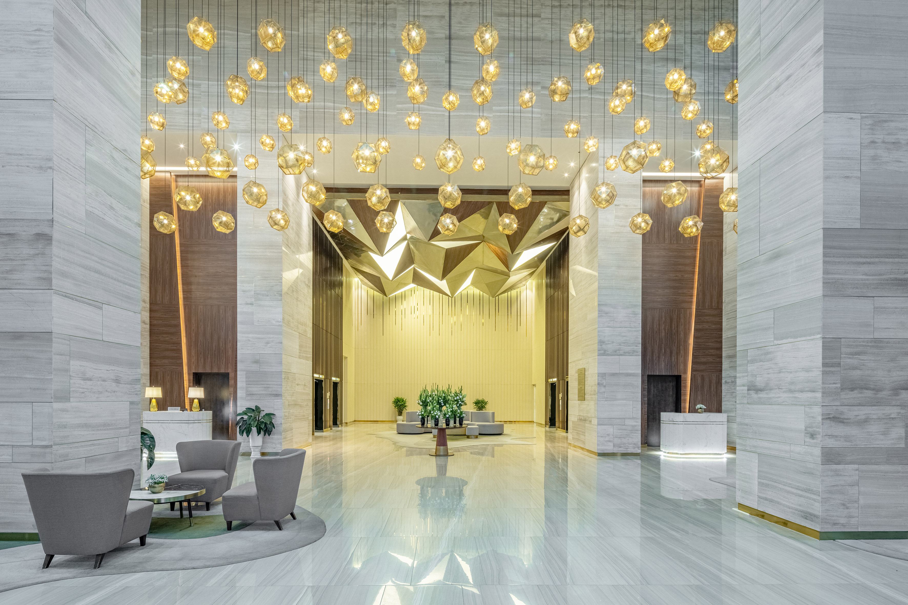 a lobby with chandeliers and chairs