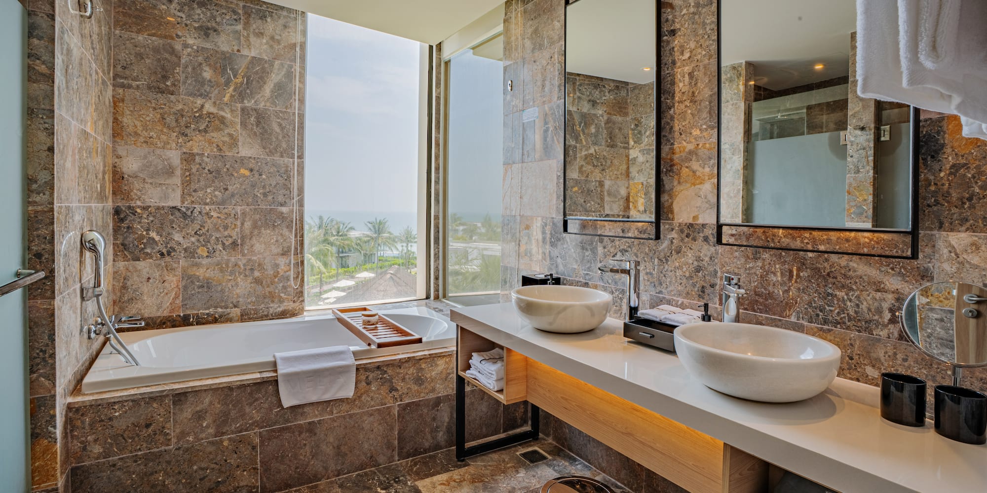 a bathroom with marble tiles and sinks