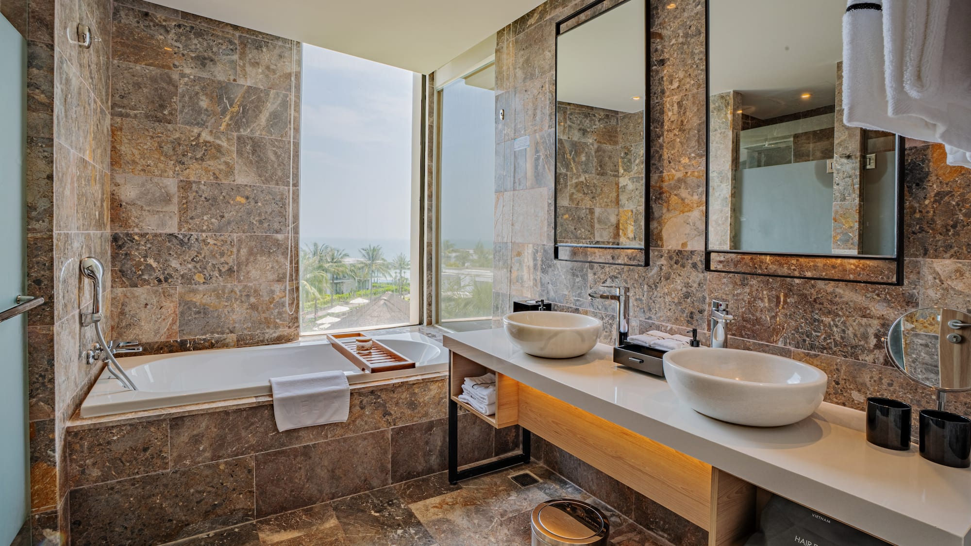 a bathroom with marble tiles and sinks