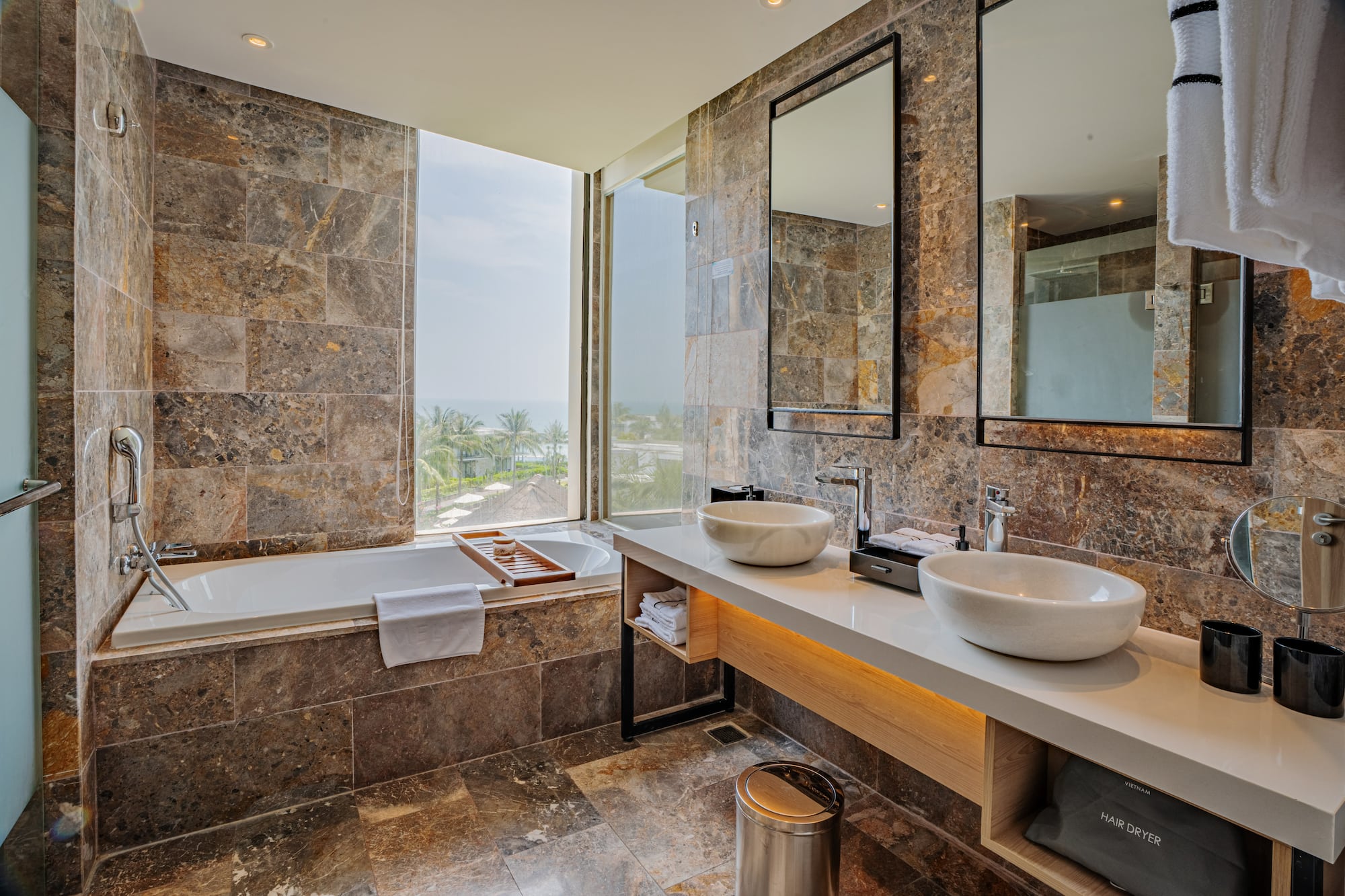 a bathroom with marble tiles and sinks