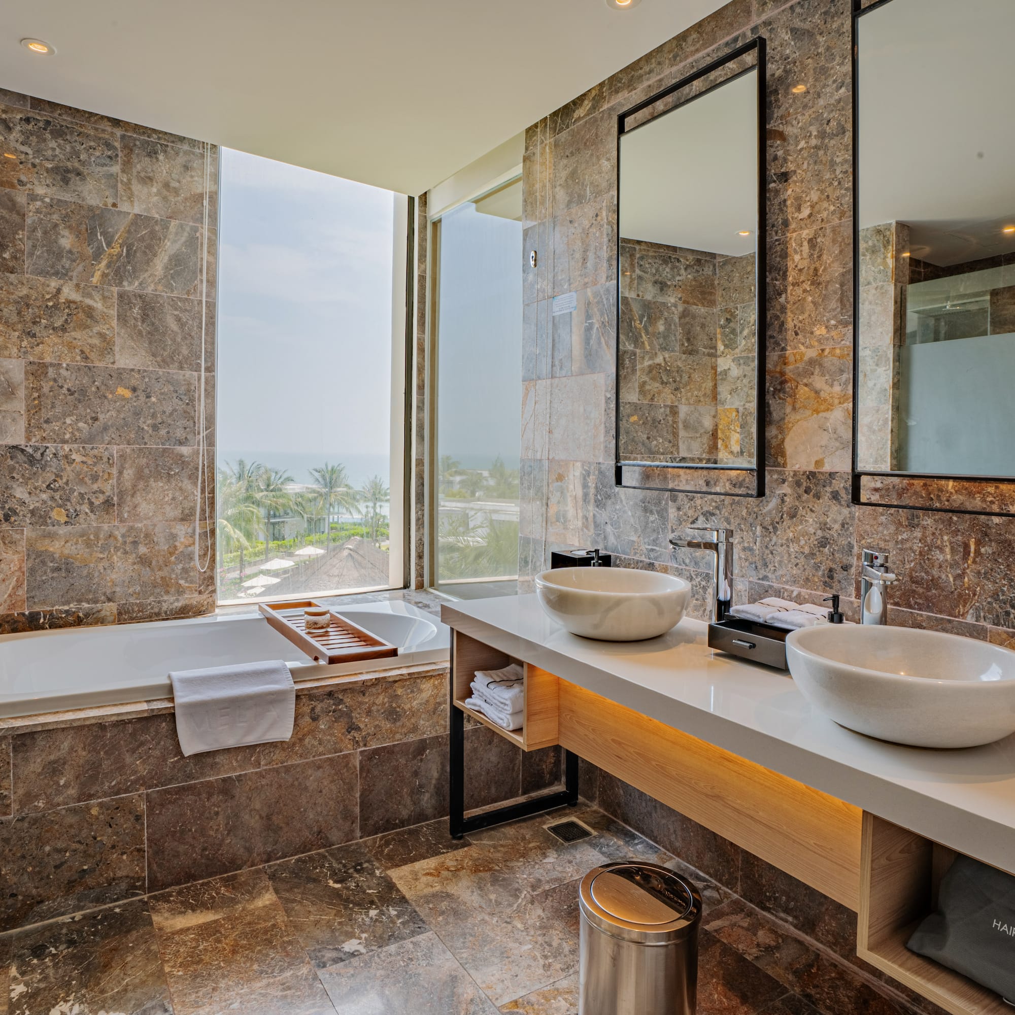 a bathroom with marble tiles and sinks