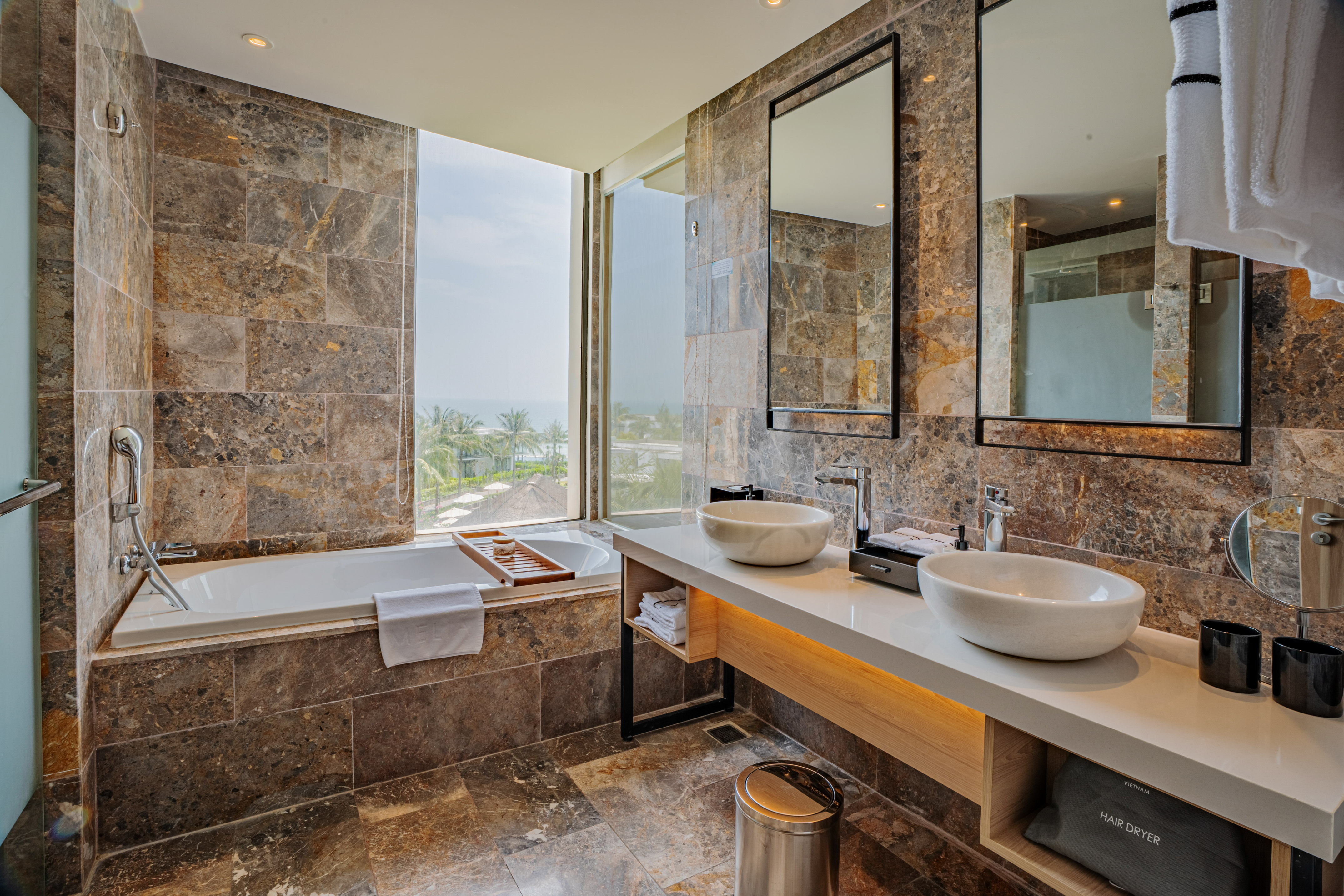 a bathroom with marble tiles and sinks