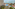 Oceanfront resort with hotel, pools, sunny beach, palm trees, and tennis court.