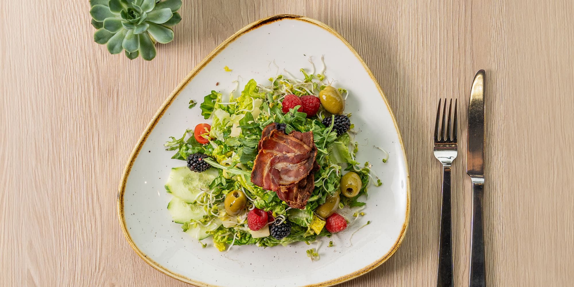 a plate of salad with a fork and knife