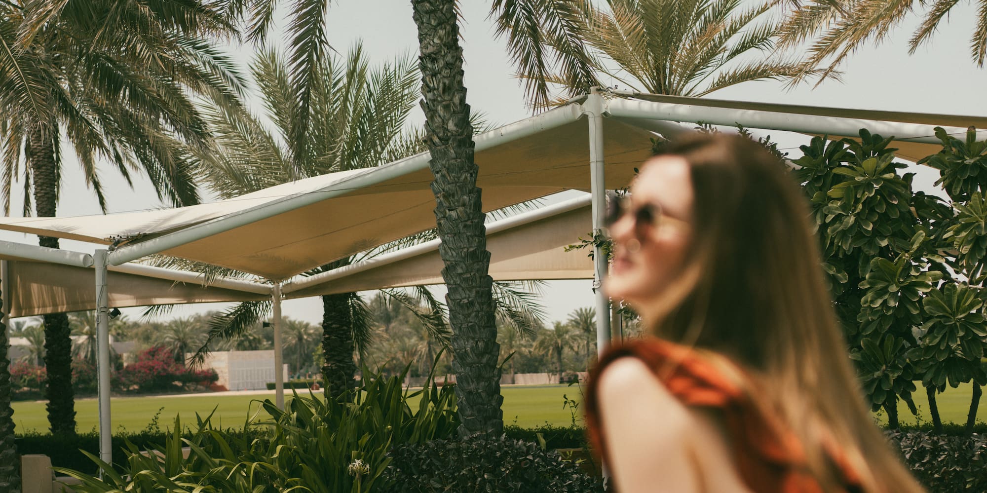 a woman sitting in a hammock near a pool