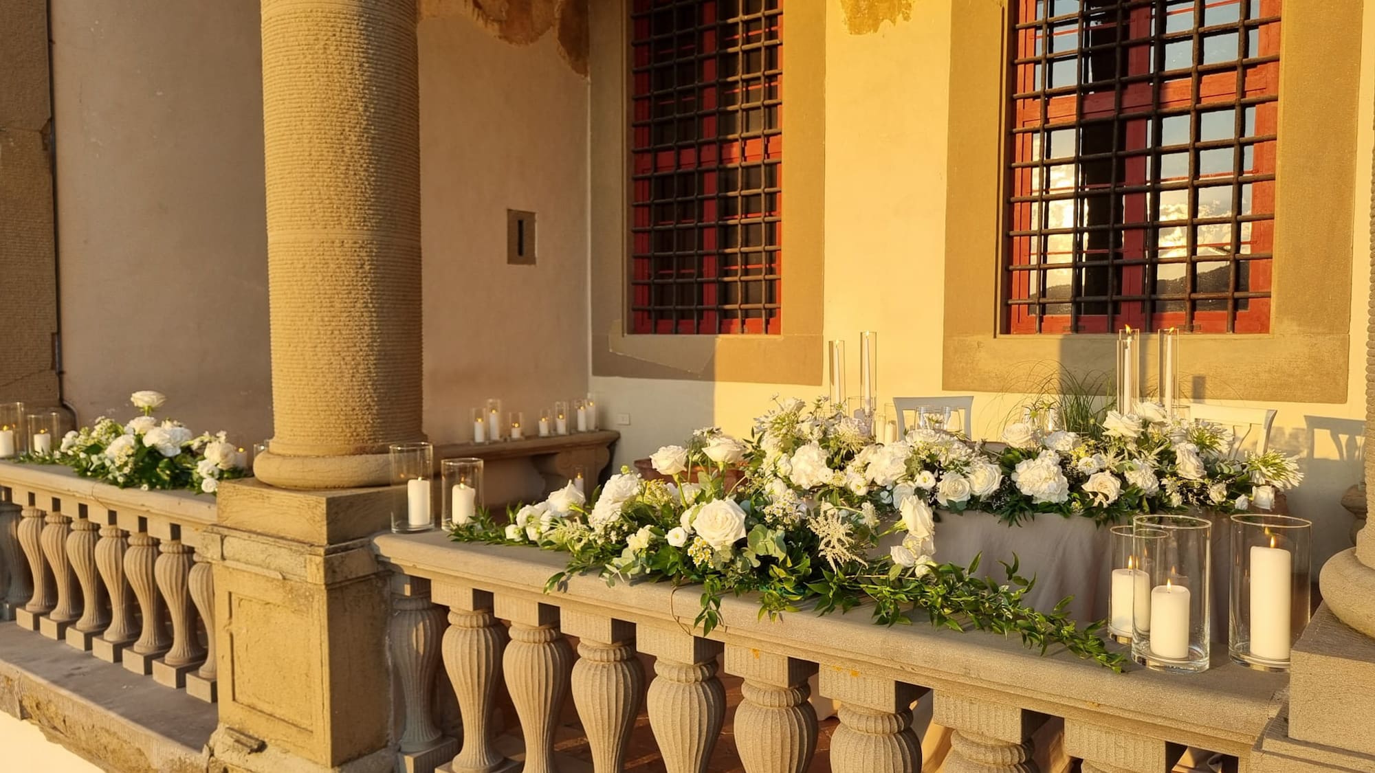 a stone railing with flowers and candles on it