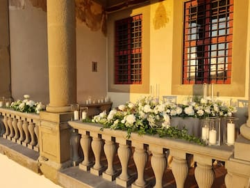 a stone railing with flowers and candles on it
