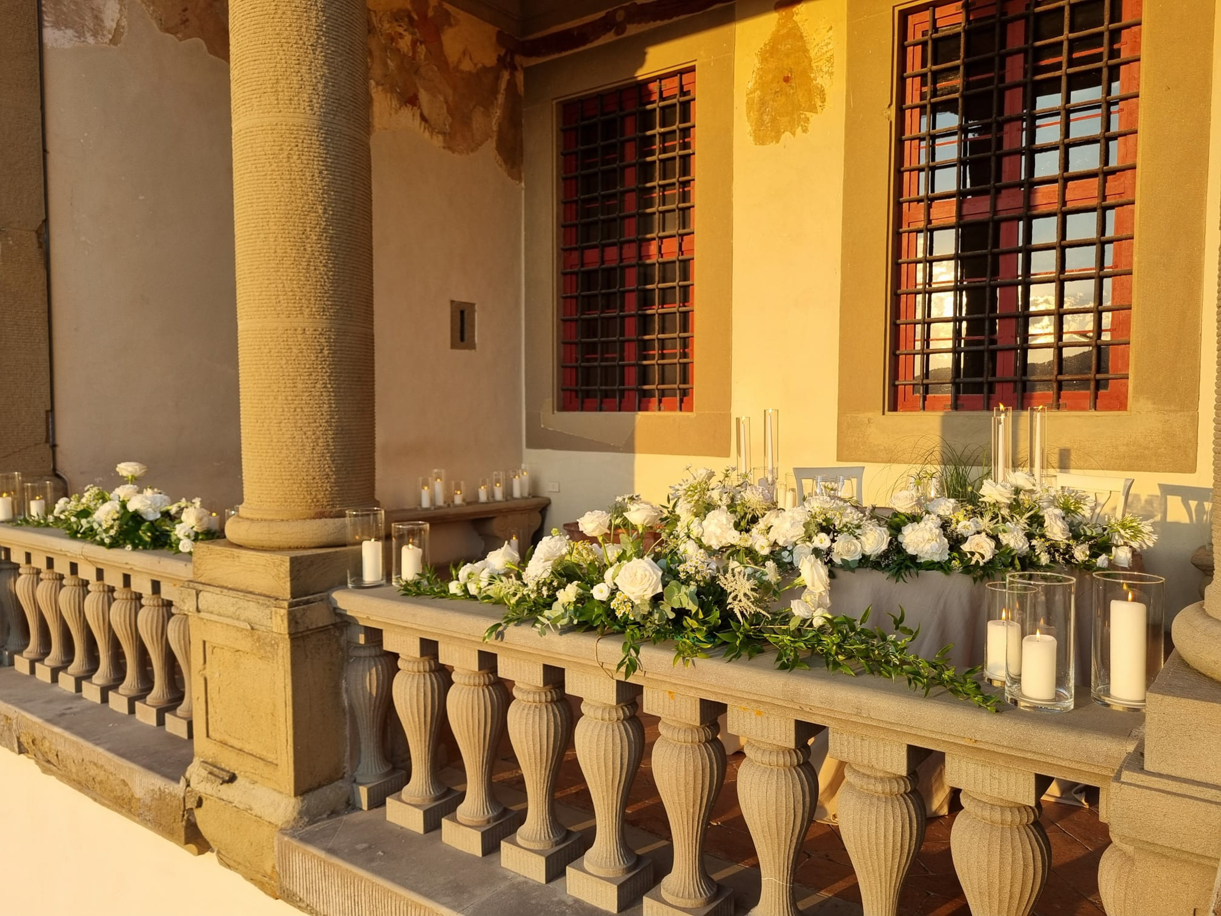 a stone railing with flowers and candles on it