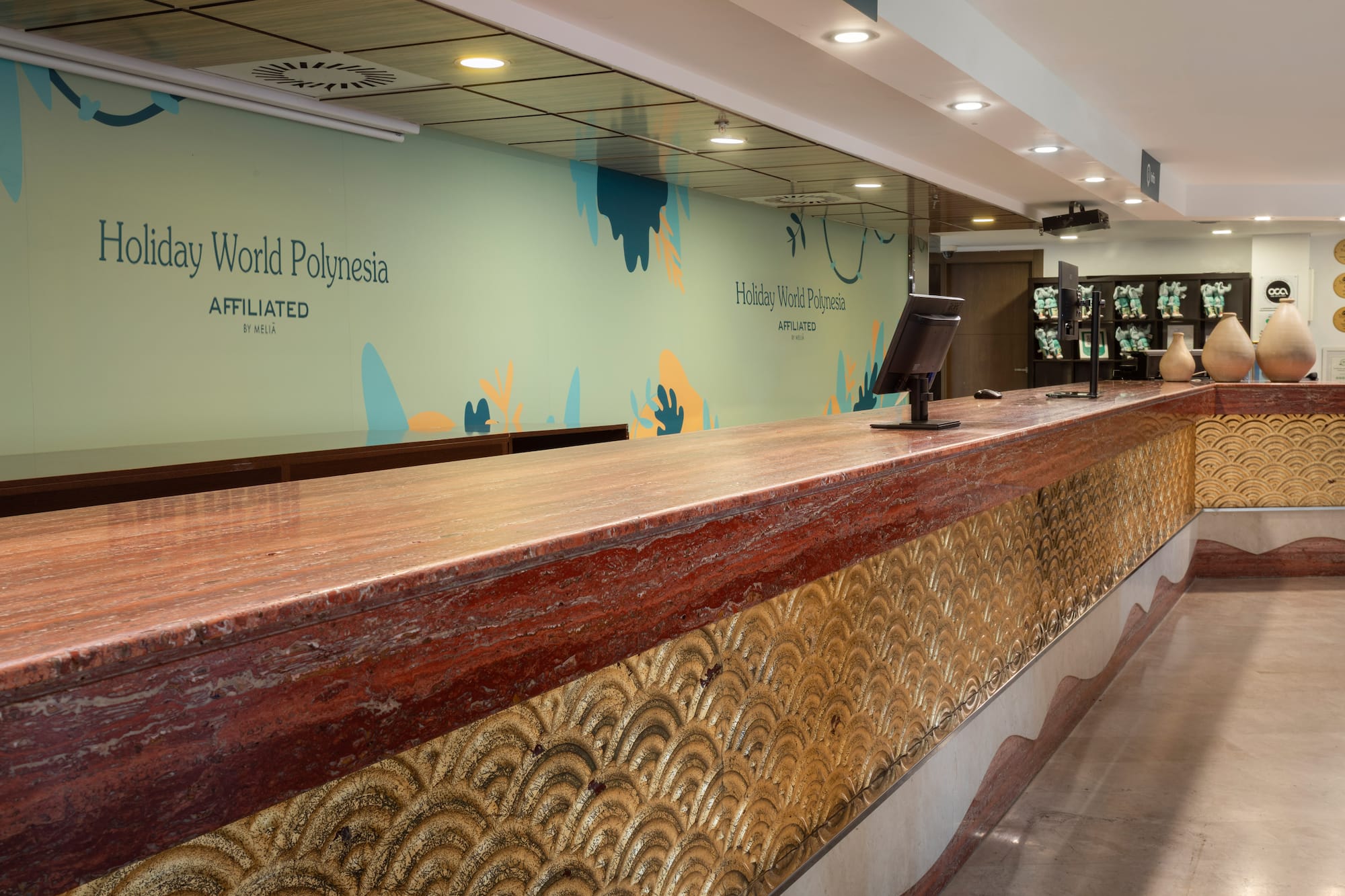 Holiday World Polynesia resort lobby desk with red marble top and gold wave base.