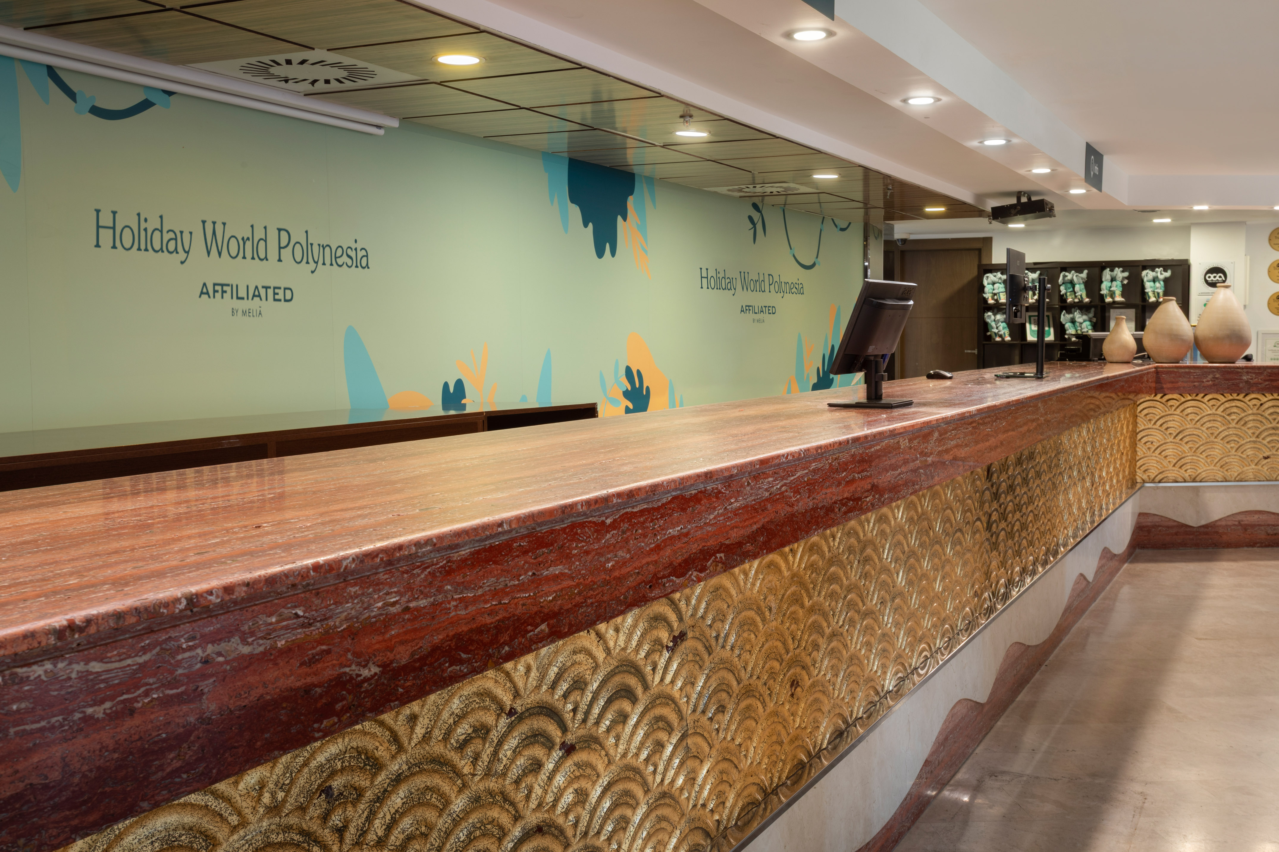 Holiday World Polynesia resort lobby desk with red marble top and gold wave base.