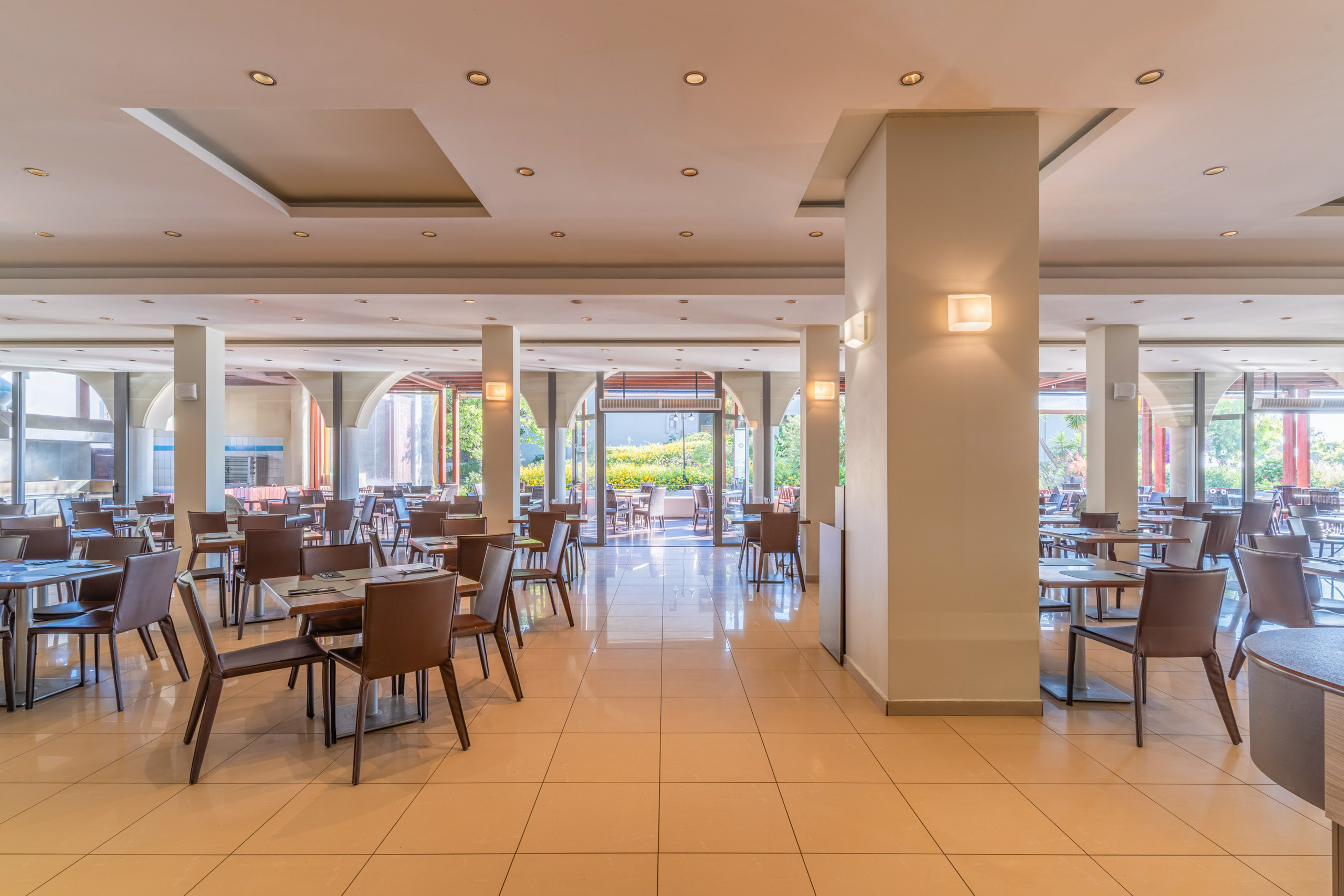 Empty modern restaurant dining area with tiled floor and outdoor view.