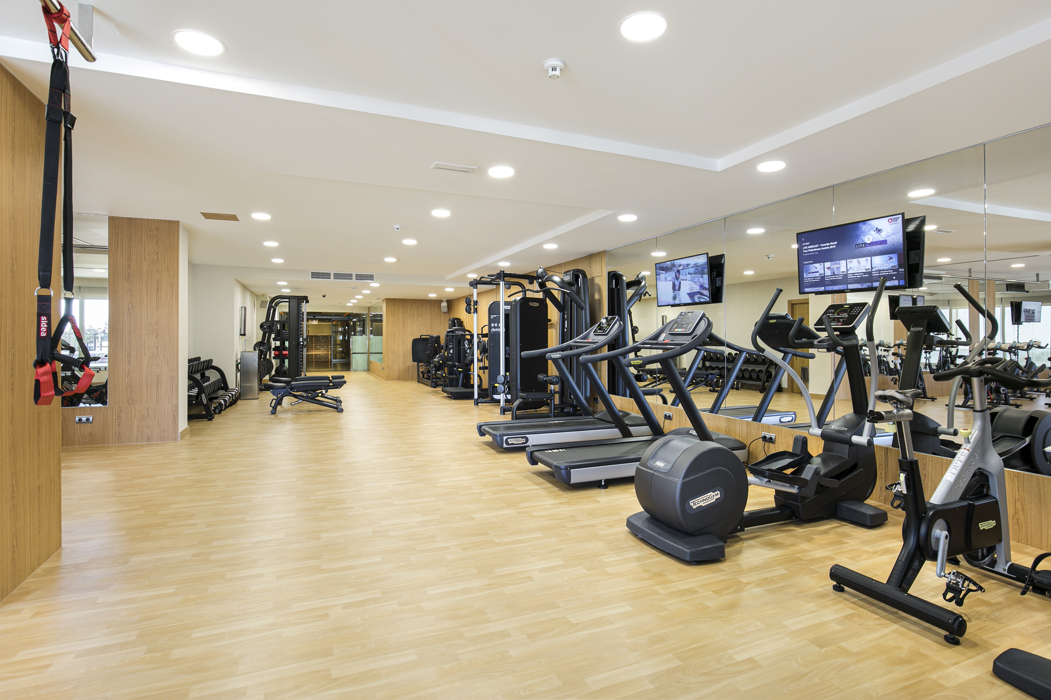 Modern gym with treadmills, ellipticals, and various workout equipment.