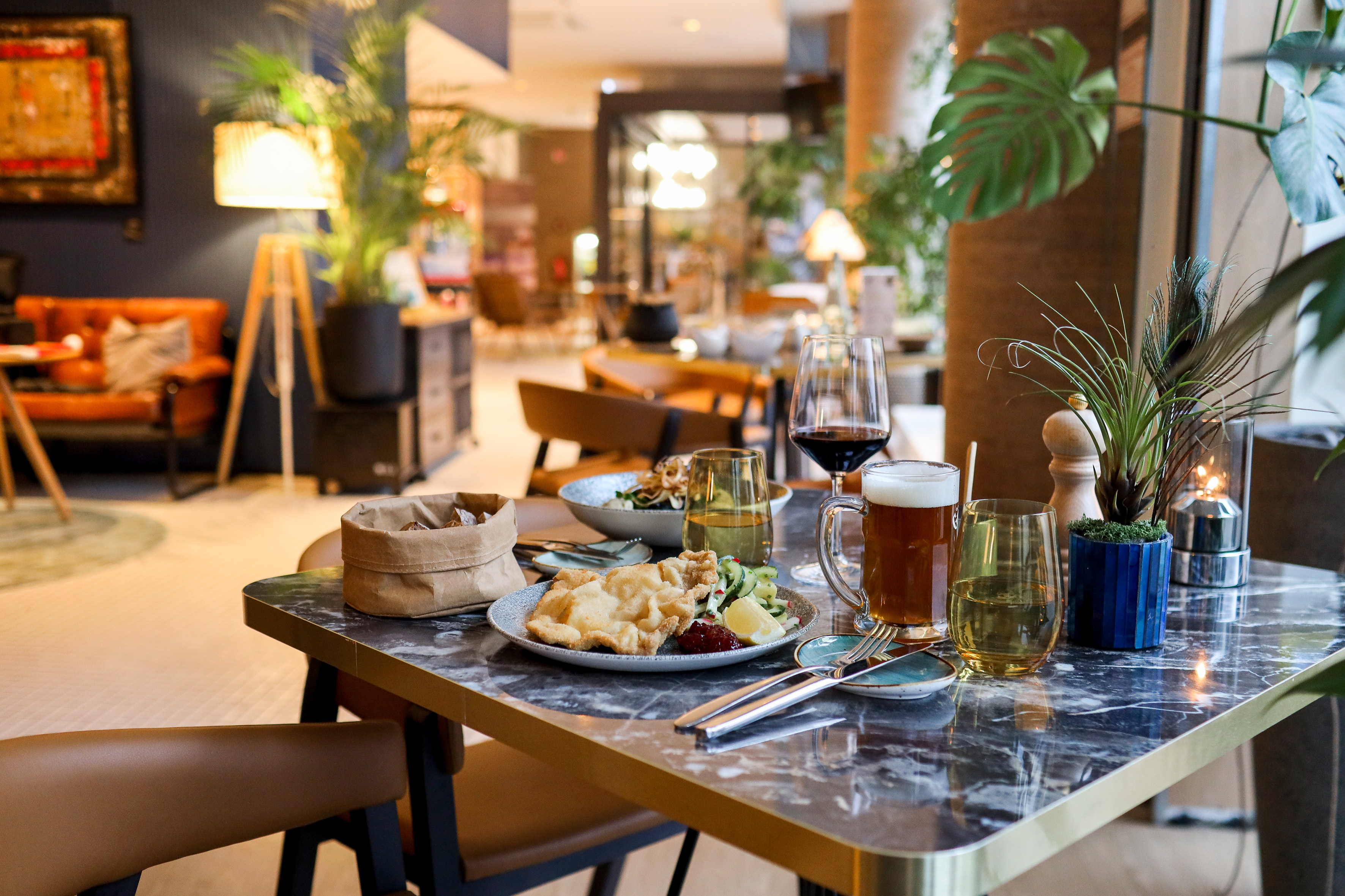 Restaurant table with fried calamari, salad, red wine, and beer.