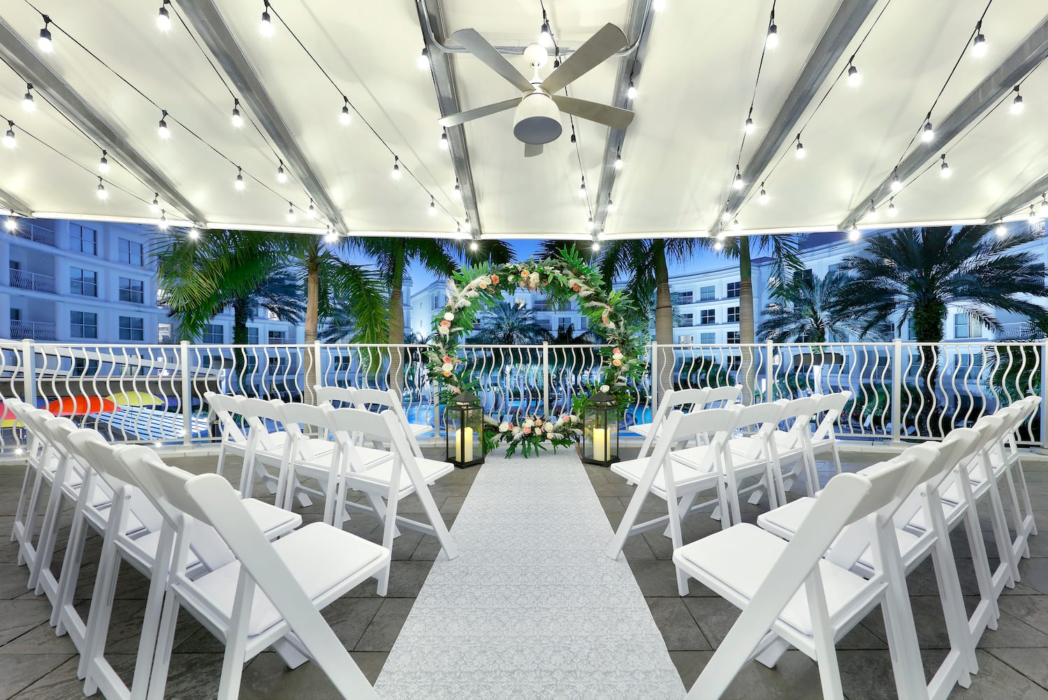 a wedding ceremony area with chairs and a white carpet