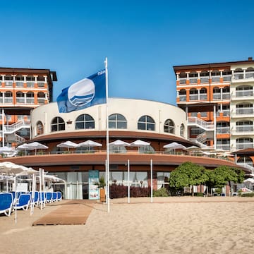 a building with a flag and umbrellas on a beach