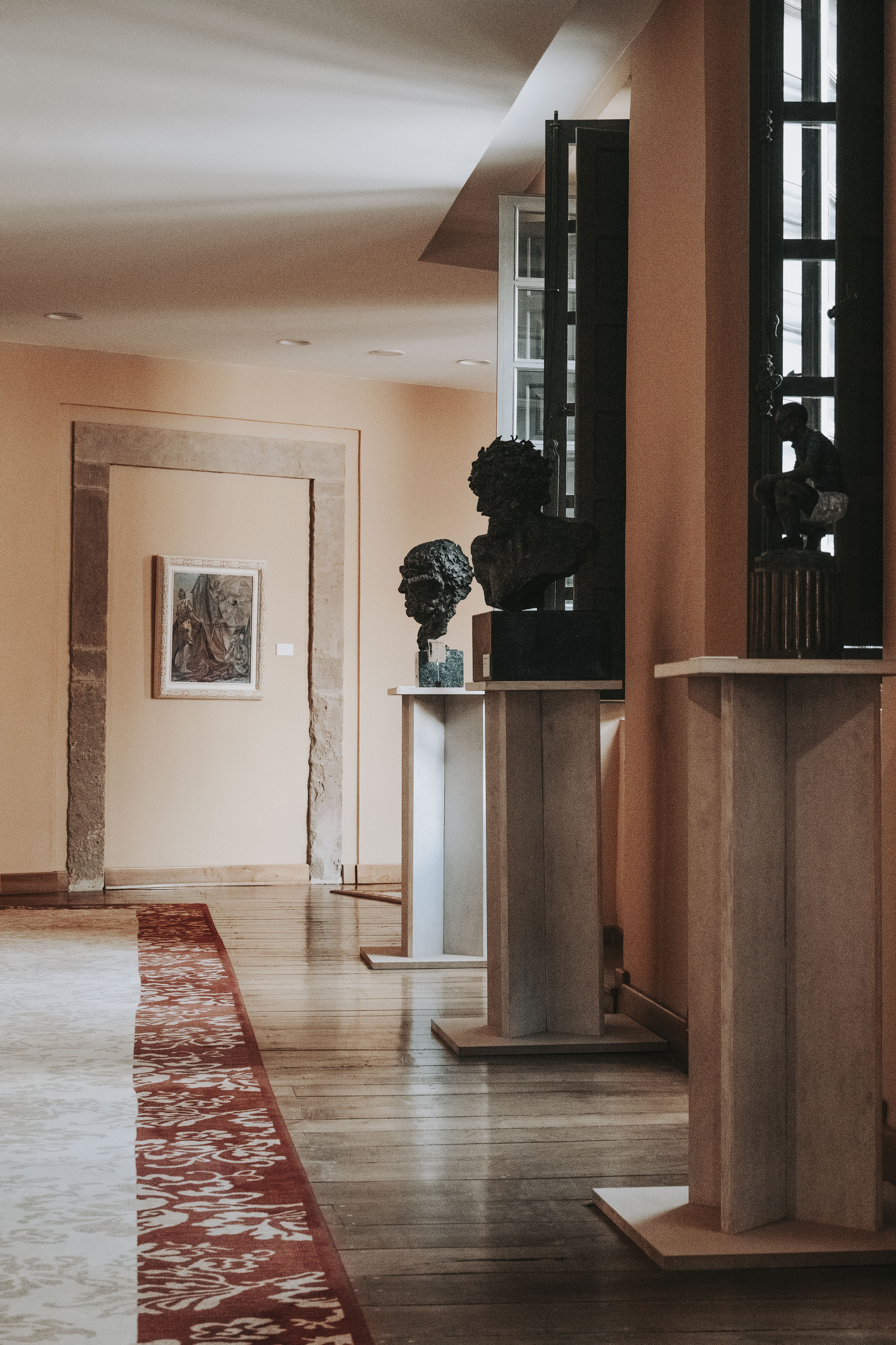 a hallway with statues on the shelves