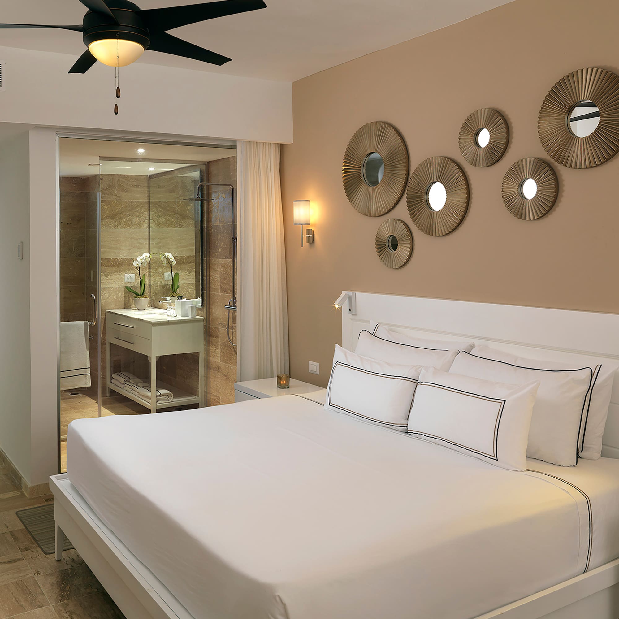 a bed with white sheets and a ceiling fan