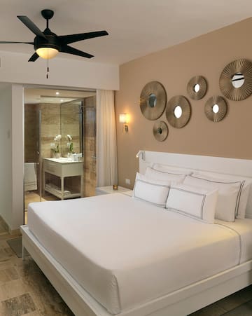 a bed with white sheets and a ceiling fan