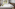 a bed with white sheets and pillows