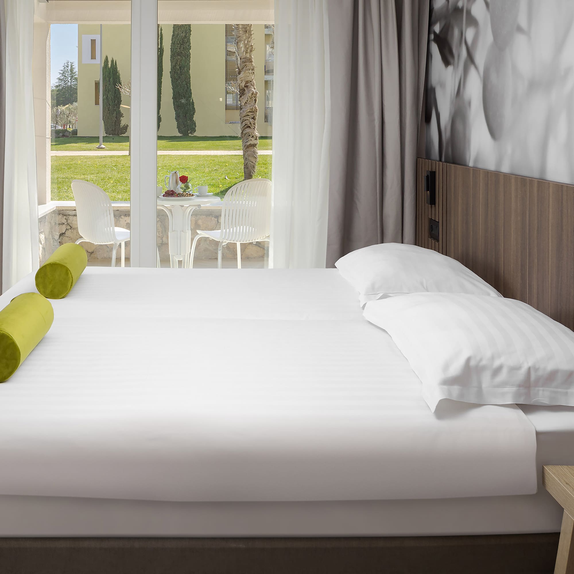 a bed with white sheets and pillows