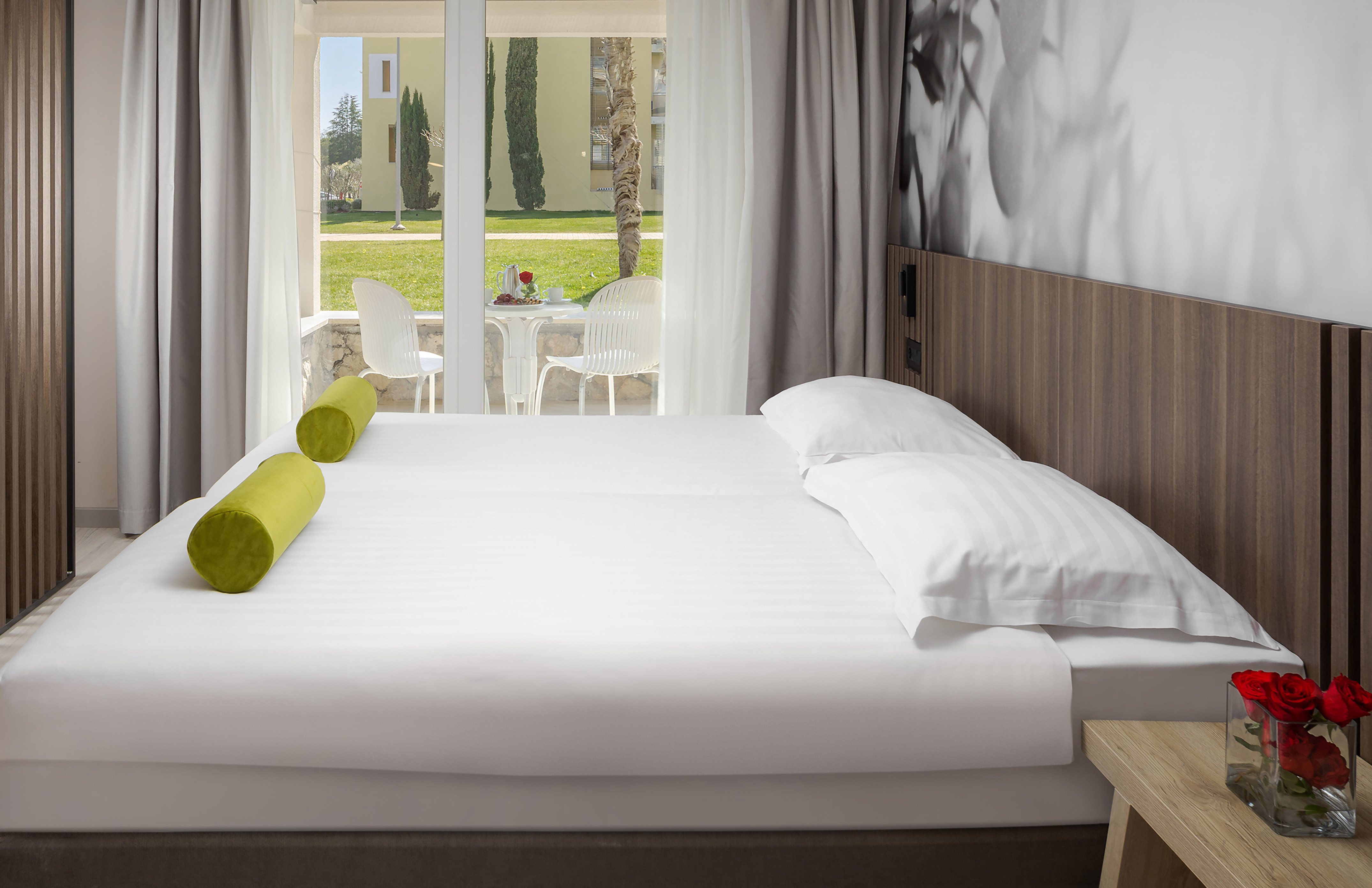a bed with white sheets and pillows